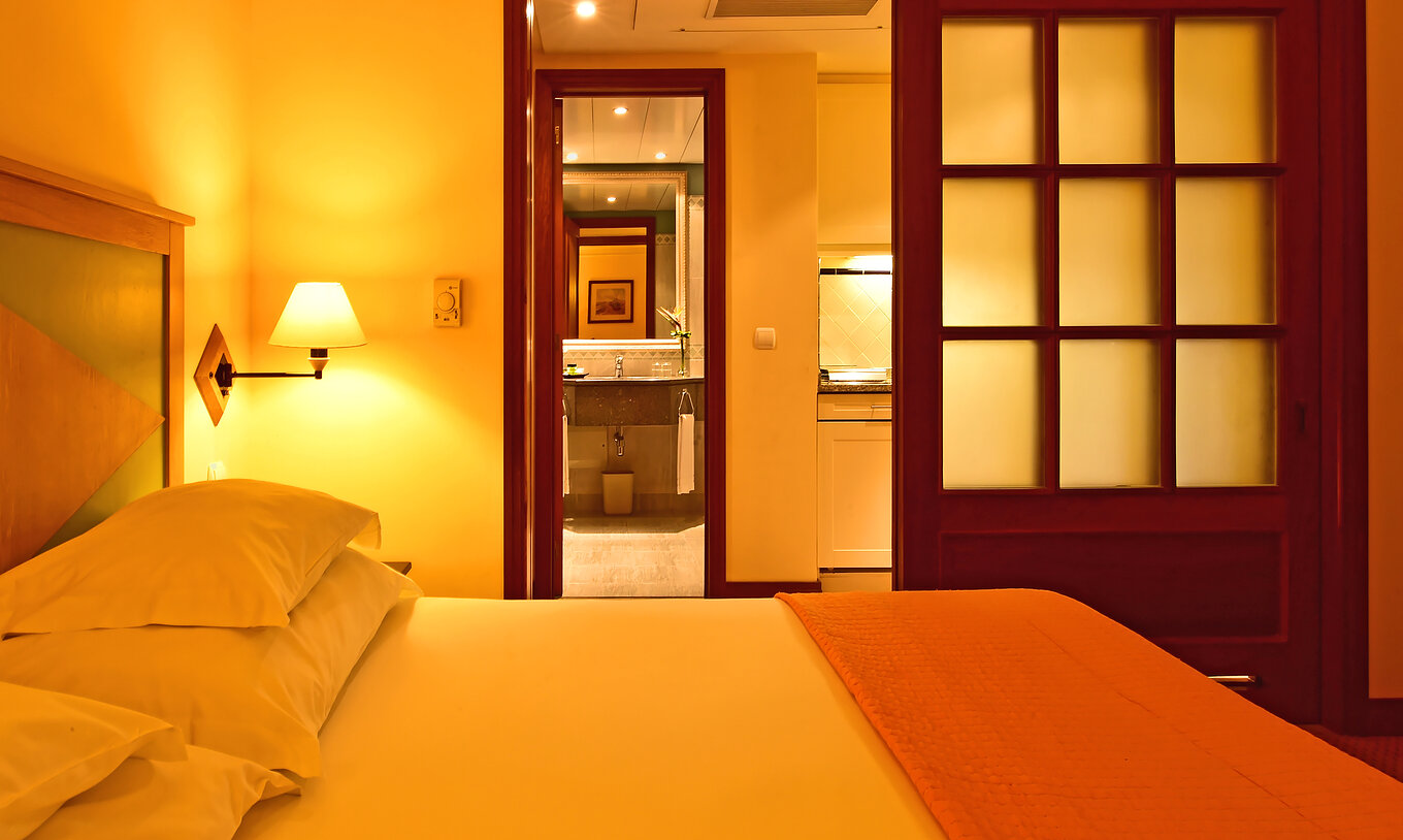 The Family Superior Room at Pestana Miramar has a double bed with a quilt and a sliding door to the bathroom