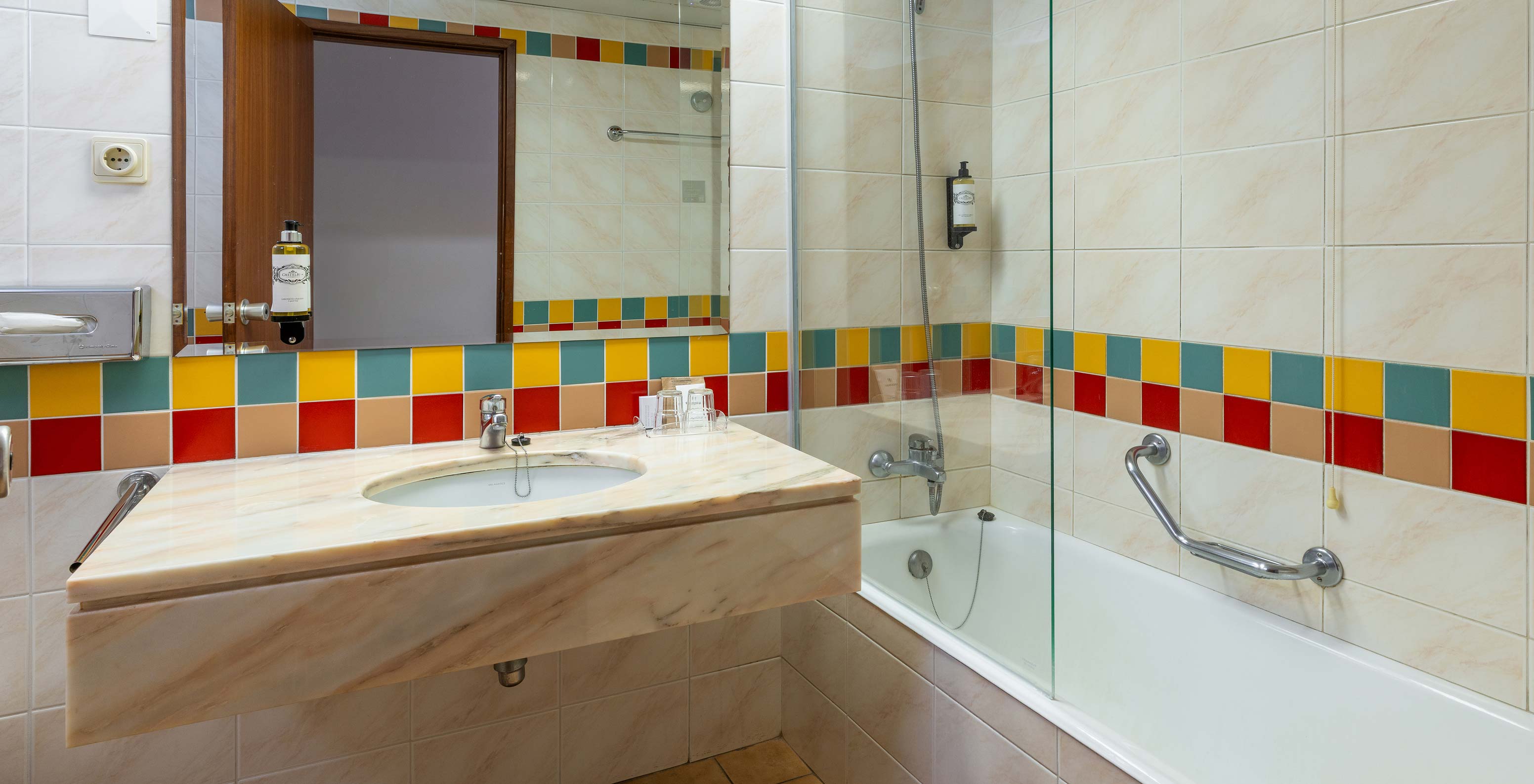 The Classic Pool View at Pestana Ocean Bay All Inclusive has a bathroom with a bathtub and a washbasin with a mirror