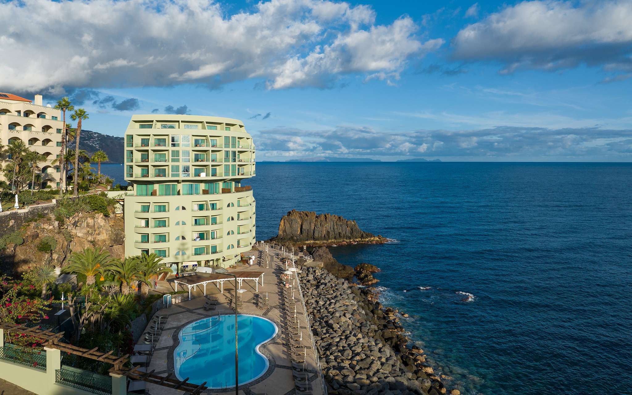 Panoramic view of the exterior of Pestana Vila Lido Madeira, a 5-star hotel in Funchal by the sea, with a pool