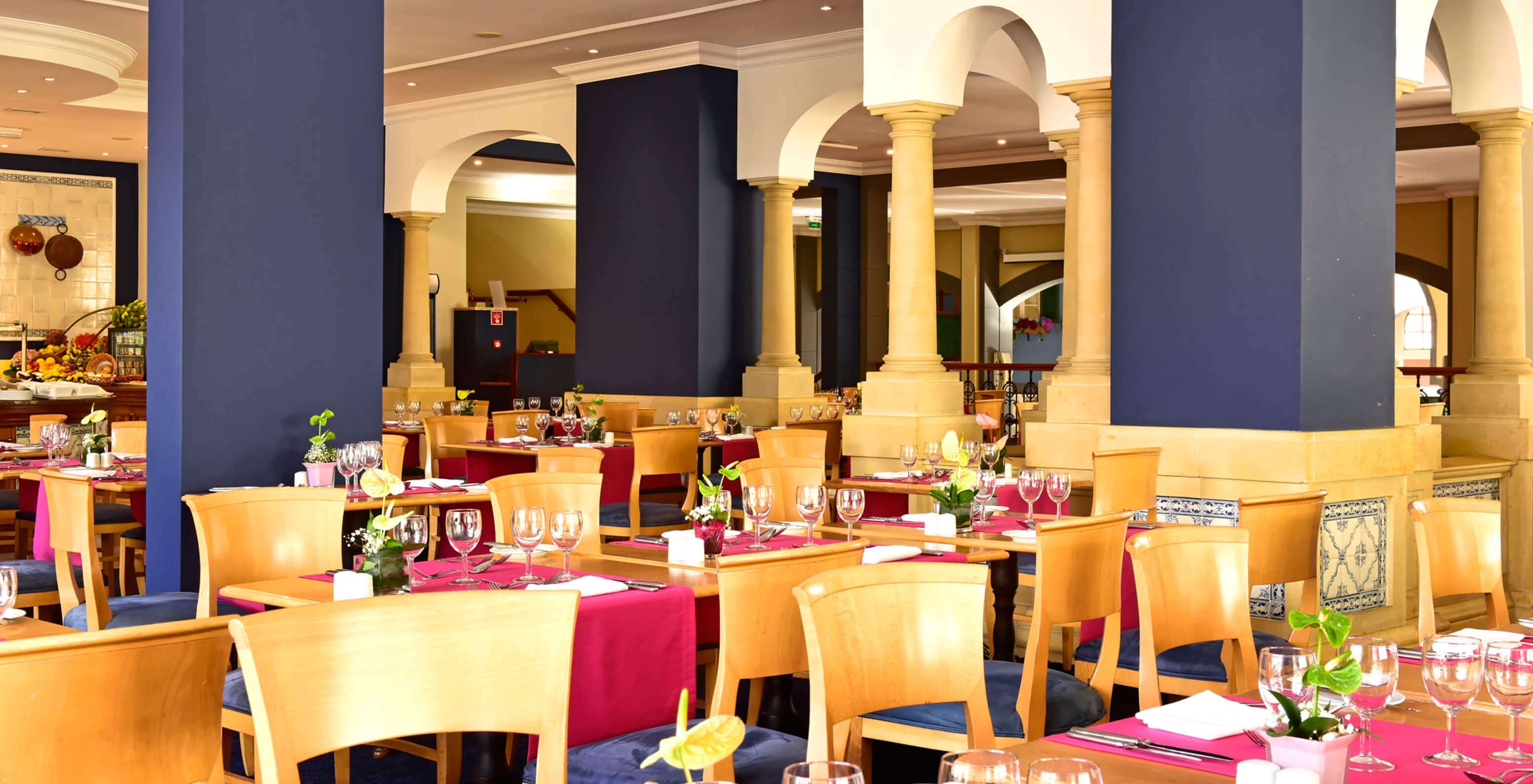 The restaurant A Vila, Romantic Hotel in Funchal, Madeira has several tables with wooden chairs