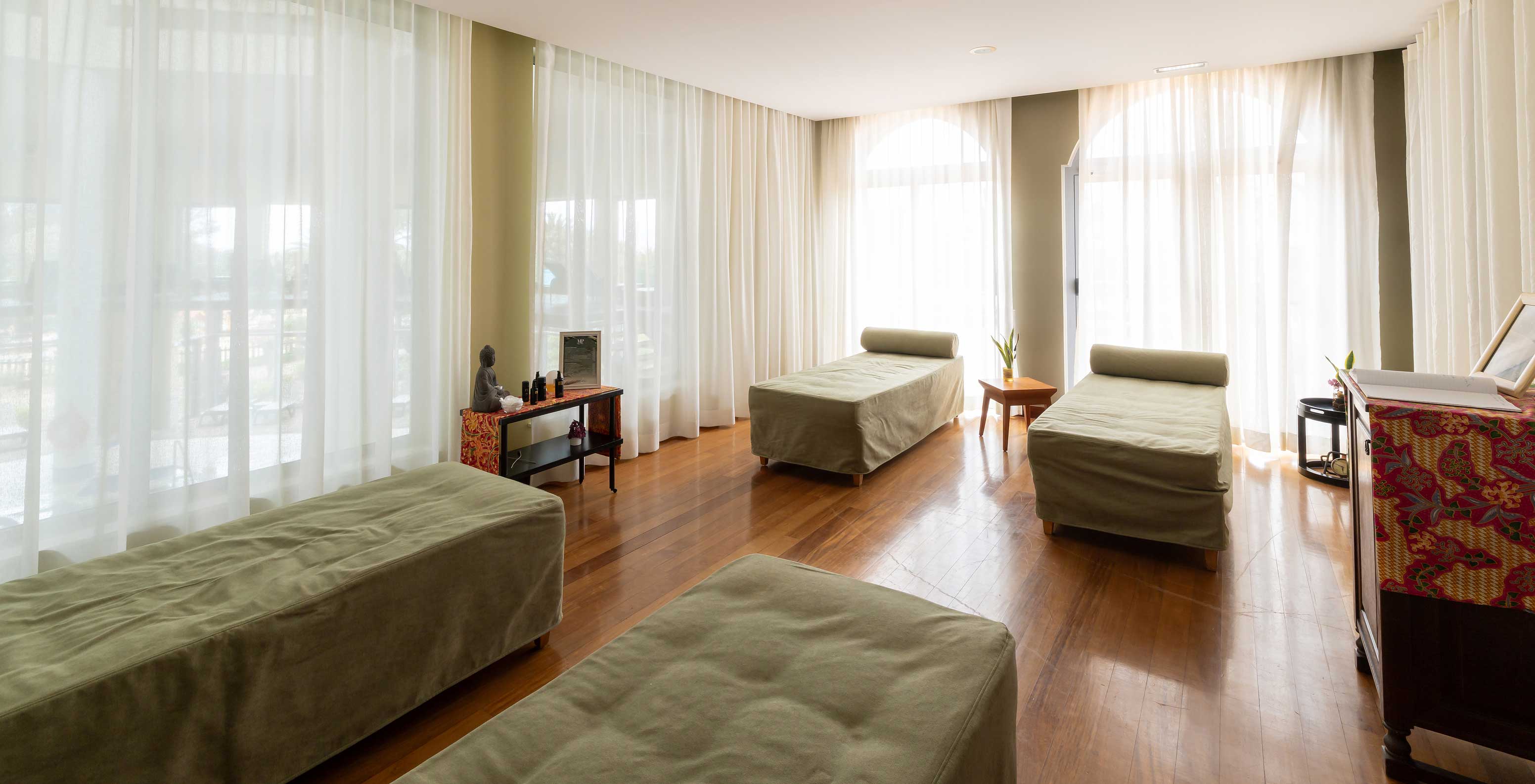 Massage room at Pestana Porto Santo, with four massage tables covered with green towels