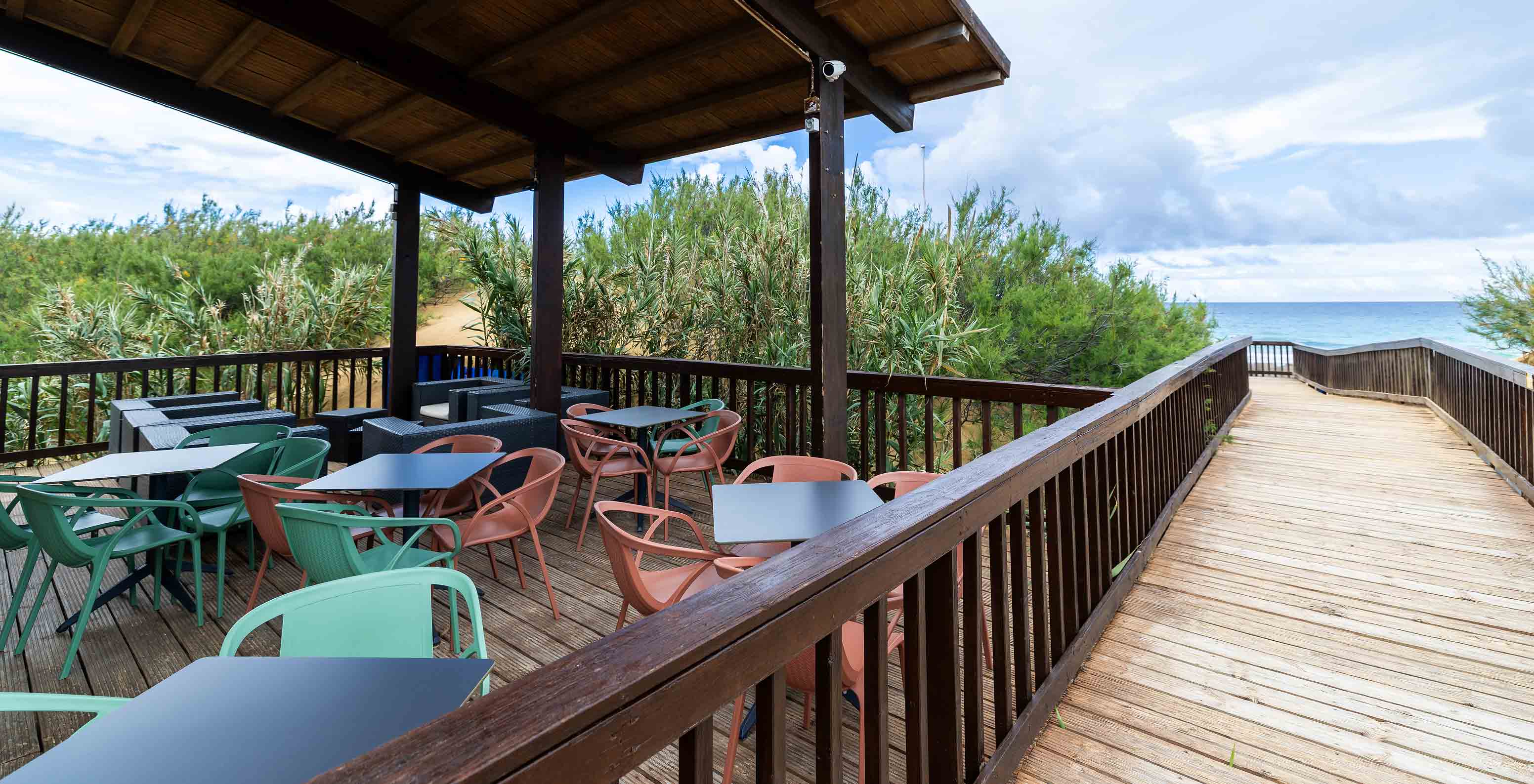 The Beach Bar restaurant at the 5-star Resort in Porto Santo has a wooden walkway, sea view, and terrace.