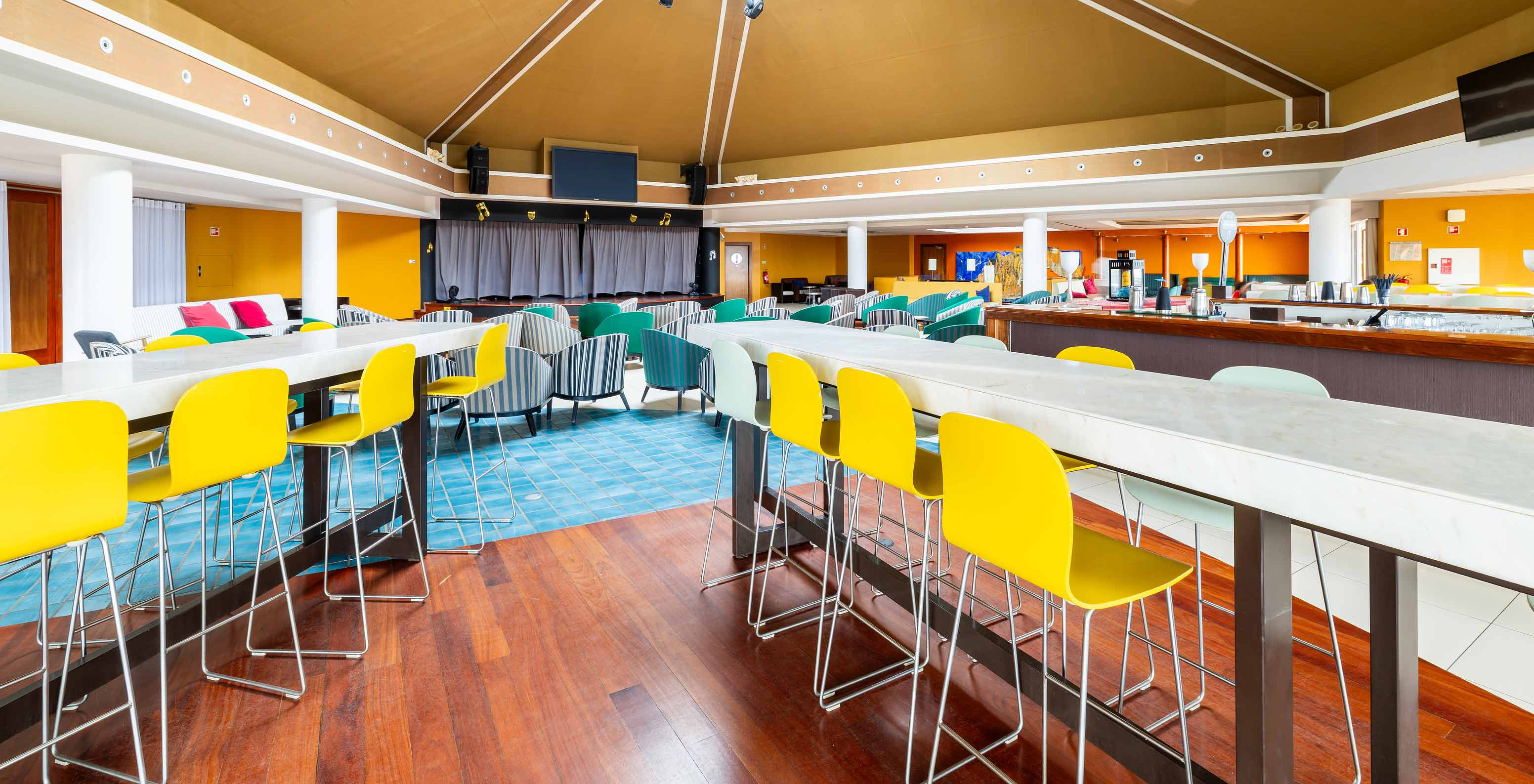 The Sunset bar at the 5-star Resort in Porto Santo has high tables with yellow and white stools.