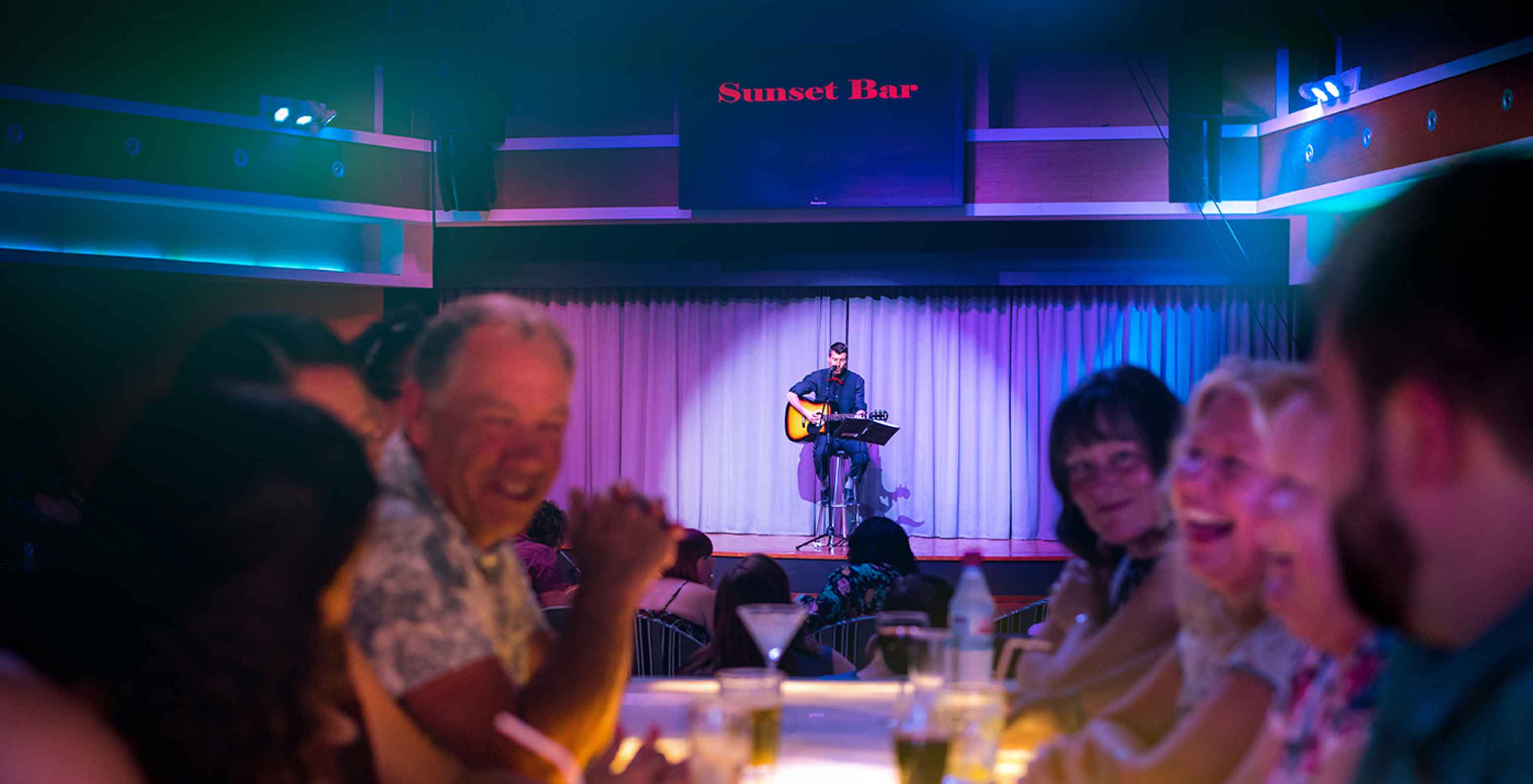 Sunset Bar, 5-star Resort in Porto Santo has a stage with a man singing and people watching