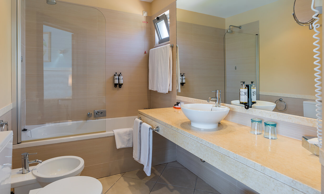 The T1 Suite Apartment of Pestana Porto Santo All Inclusive has a bathroom with bidet, sink, mirror, and bathtub