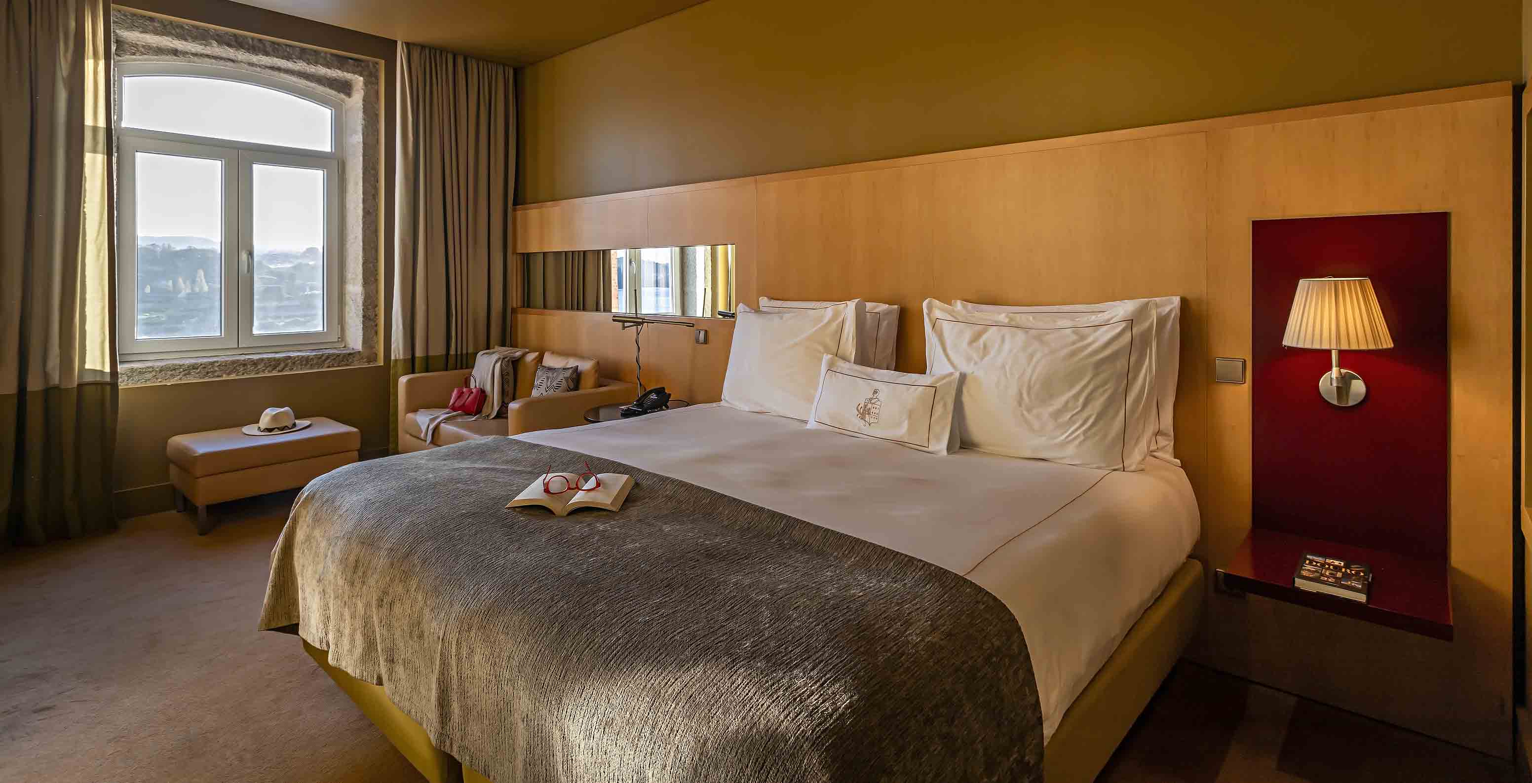 The Executive Superior has a double bed, a sofa, and a pouf by the window