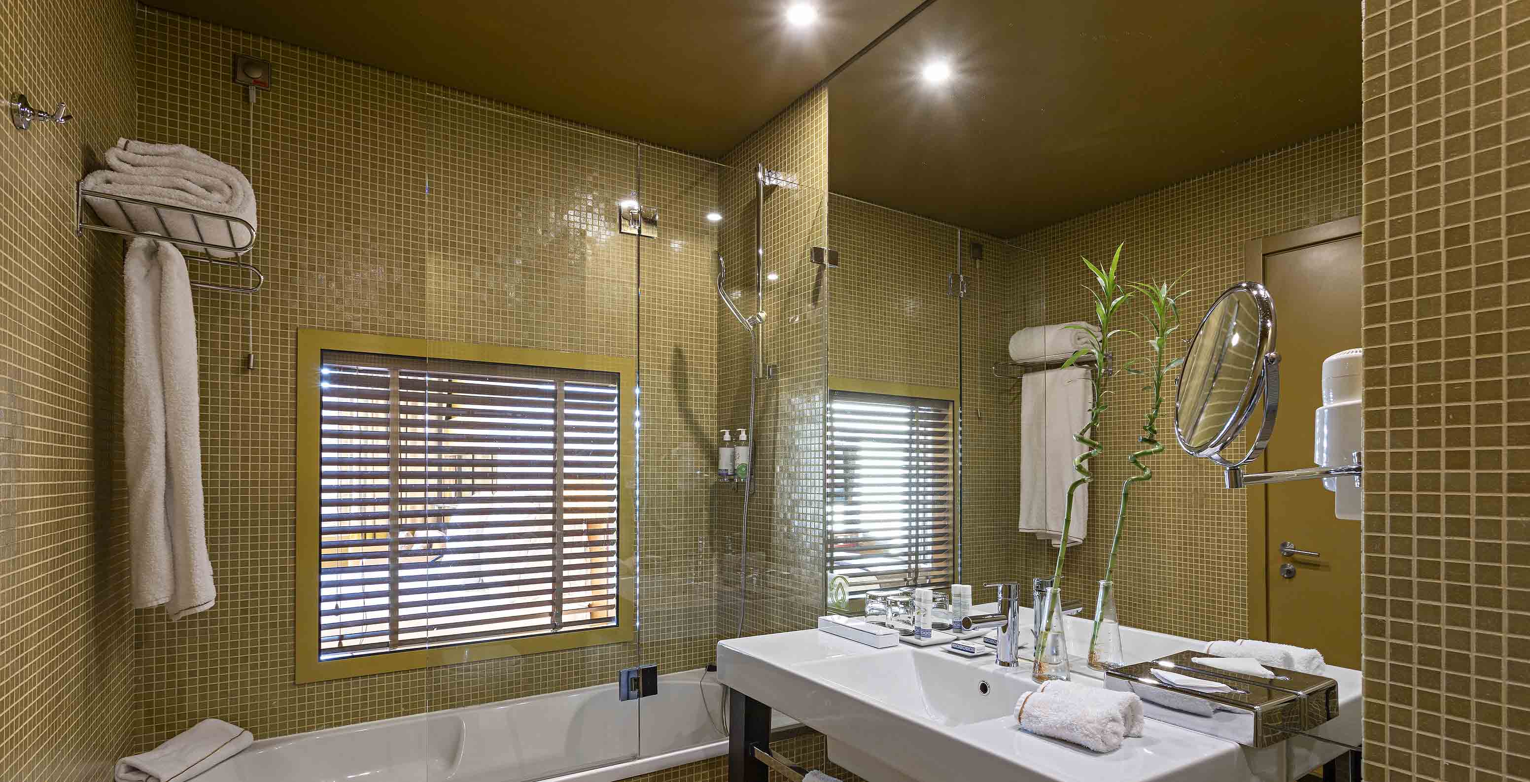 The Executive Superior has a bathroom with a bathtub and a window into the bedroom