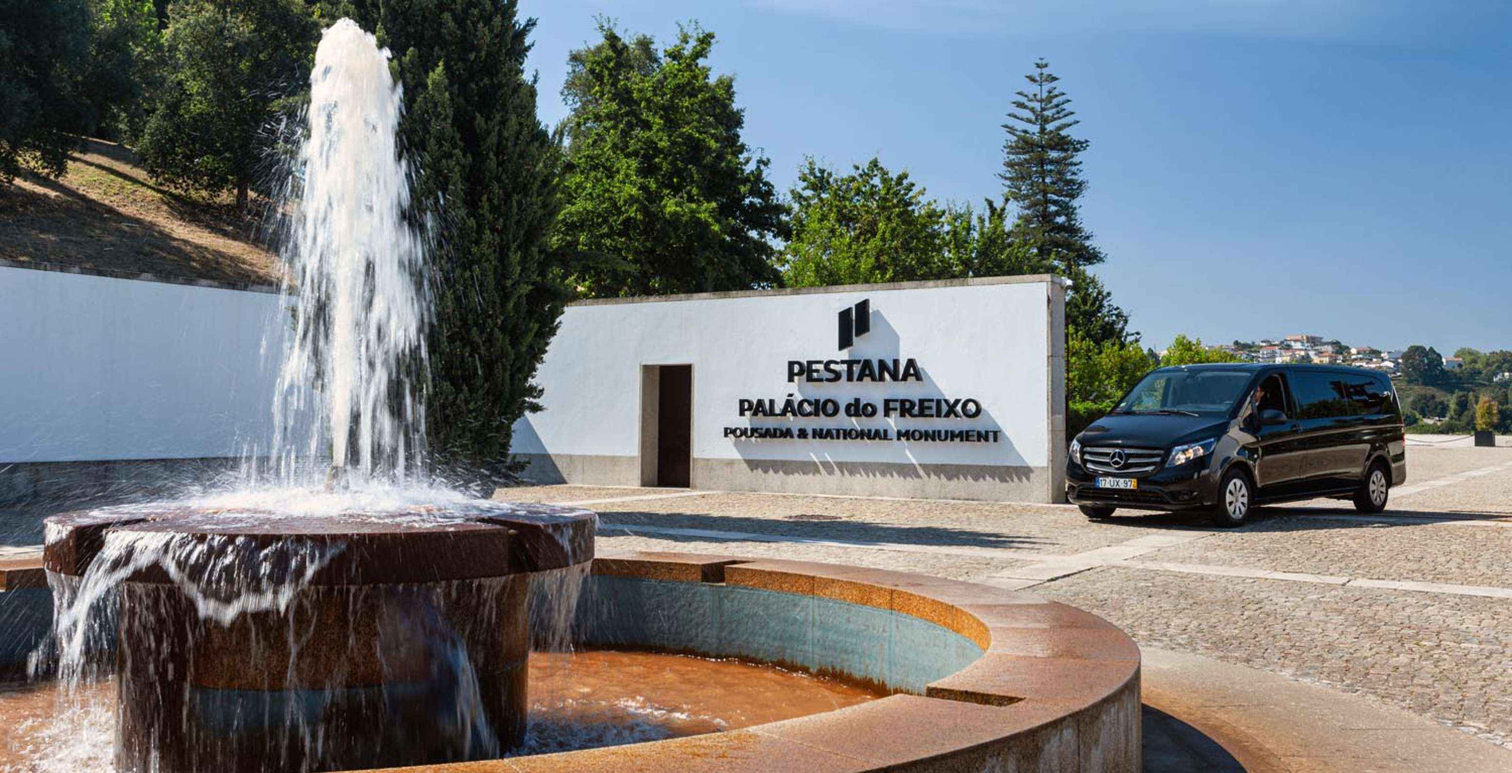 Fountain at the entrance of Pestana Palácio do Freixo and a sign reading Pestana Palácio do Freixo Pousada & National Monument