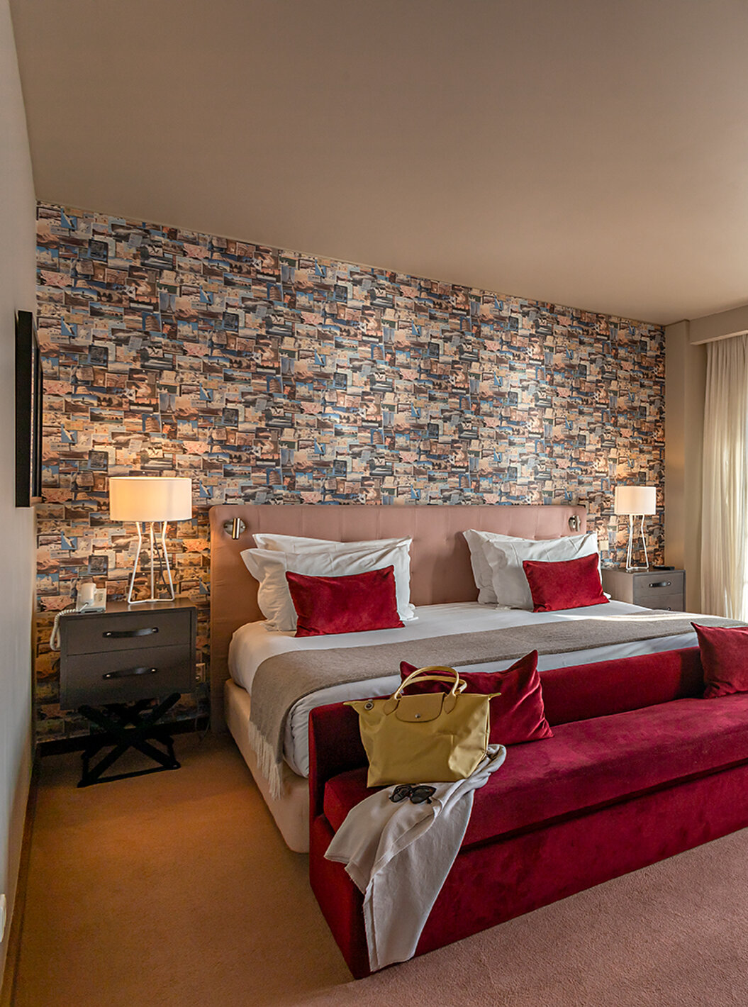 The Suite Grand View at Pestana Vintage Porto has a double bed, a red sofa and windows with a view of Porto