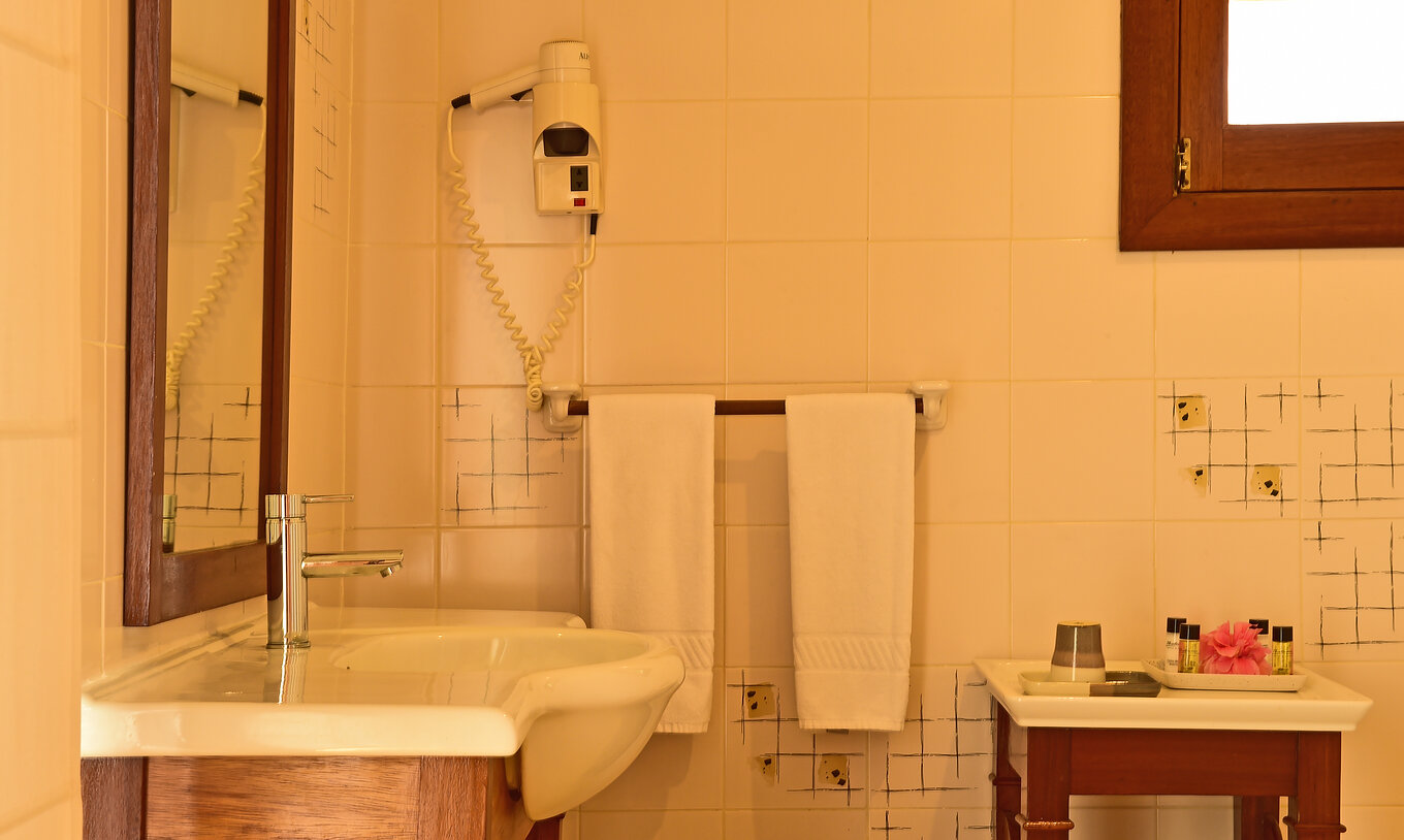 The Standard Double at Pestana Equador Ilheu das Rolas has a bathroom with a sink, mirror, and hairdryer