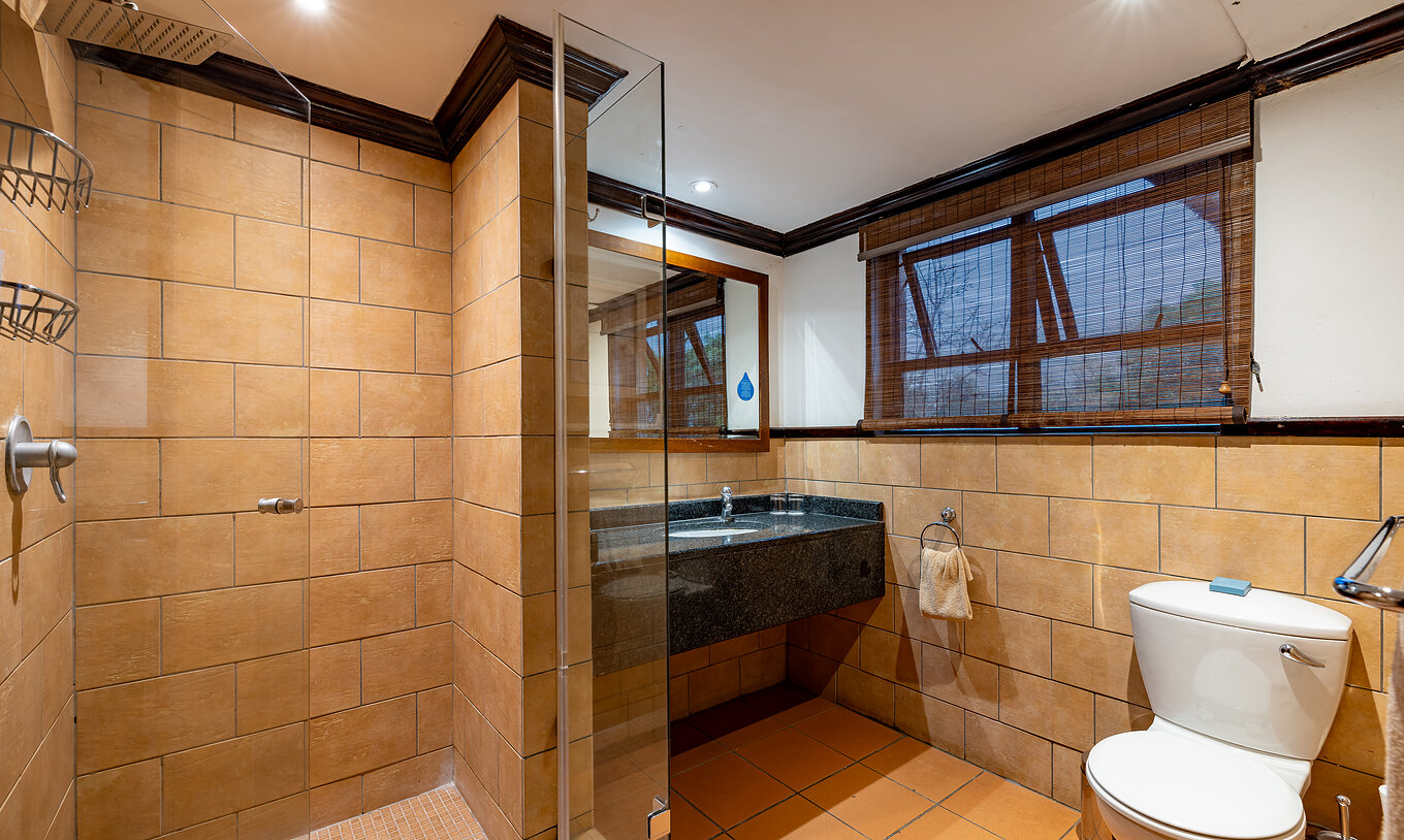 The Standard Room at Pestana Kruger Lodge has a bathroom with shower, sink with mirror, toilet and window