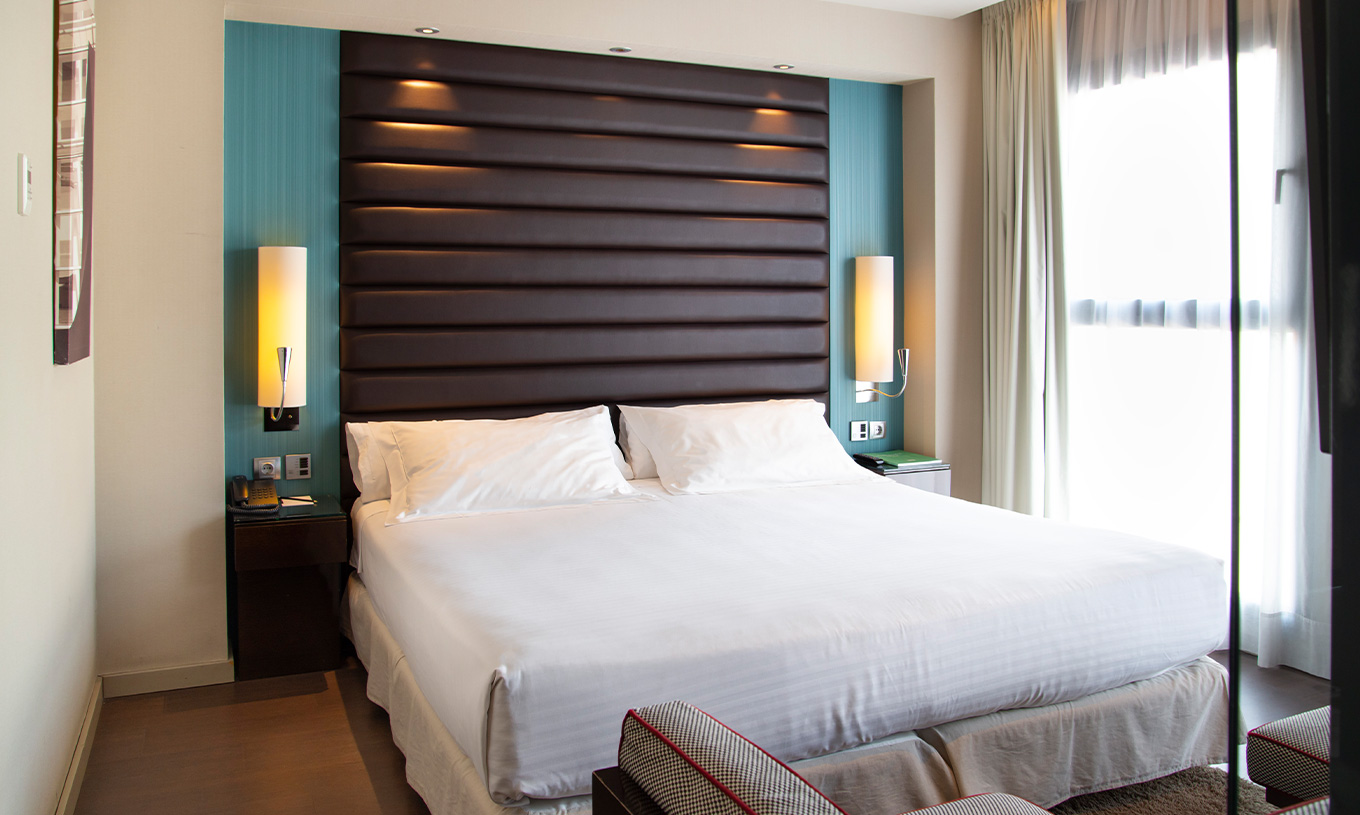 Deluxe room at Pestana Arena Barcelona has a comfortable double bed with bedside tables and a large window