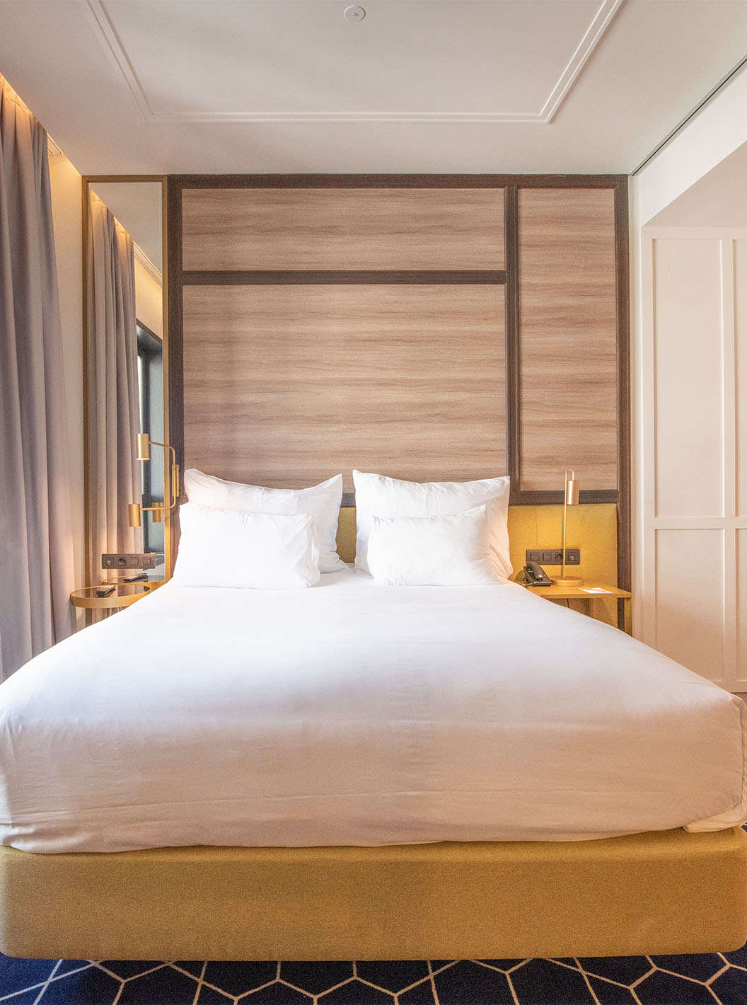 The Premium Room with View at Pestana CR7 Gran Vía Madrid includes a double bed and large window overlooking nearby buildings