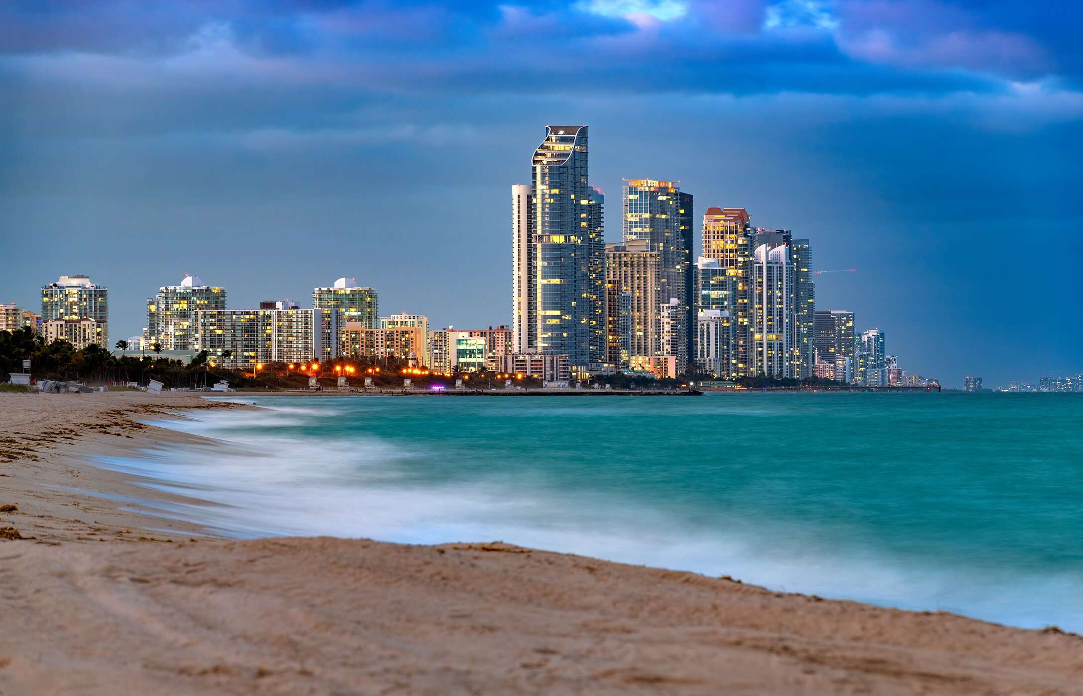 Sunny Isles Beach in Miami with crystal-clear waters, white sand, and modern buildings in the background