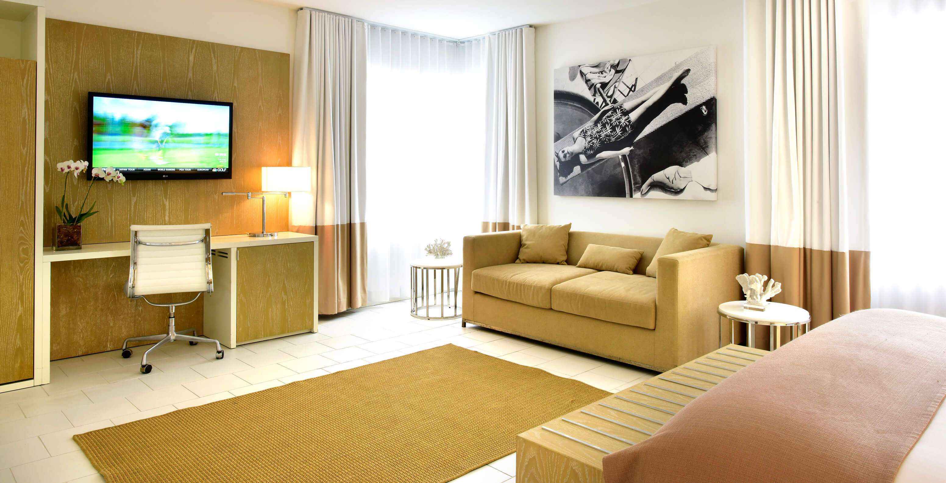 The Deluxe with Sofa Bed at Pestana Miami South Beach has a living room with sofa, desk and TV