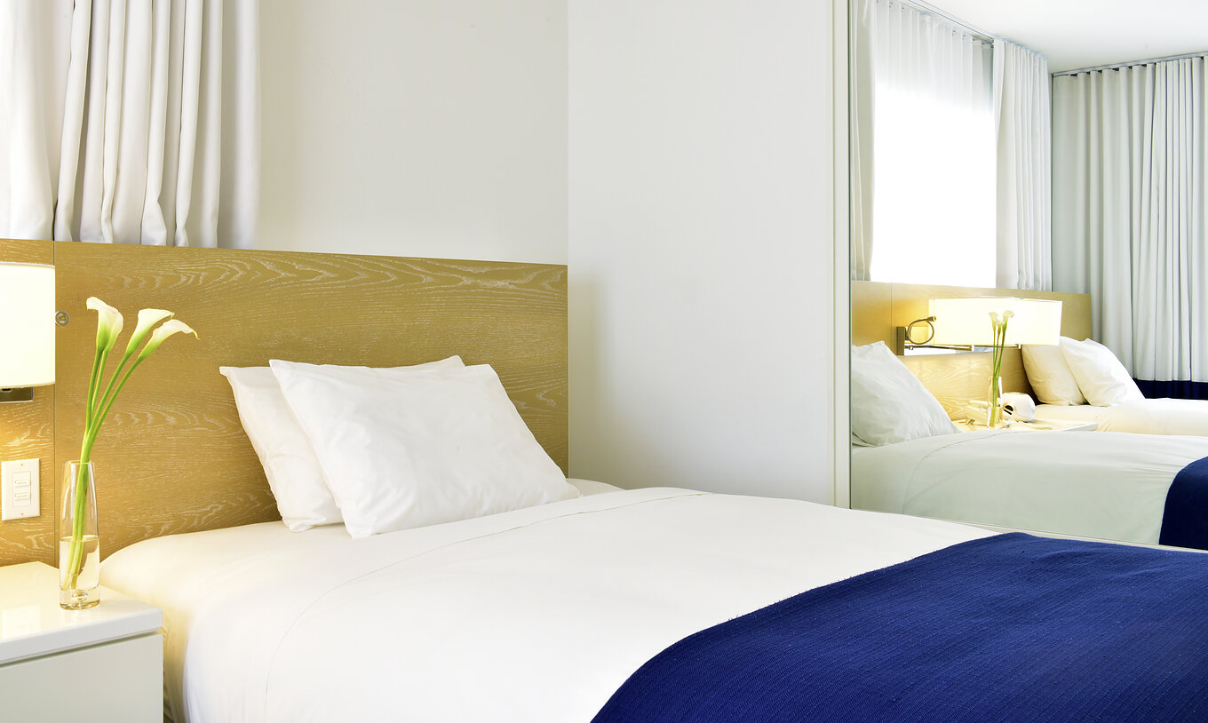The Classic Double Beds at Pestana Miami South Beach has a bed and a large mirror
