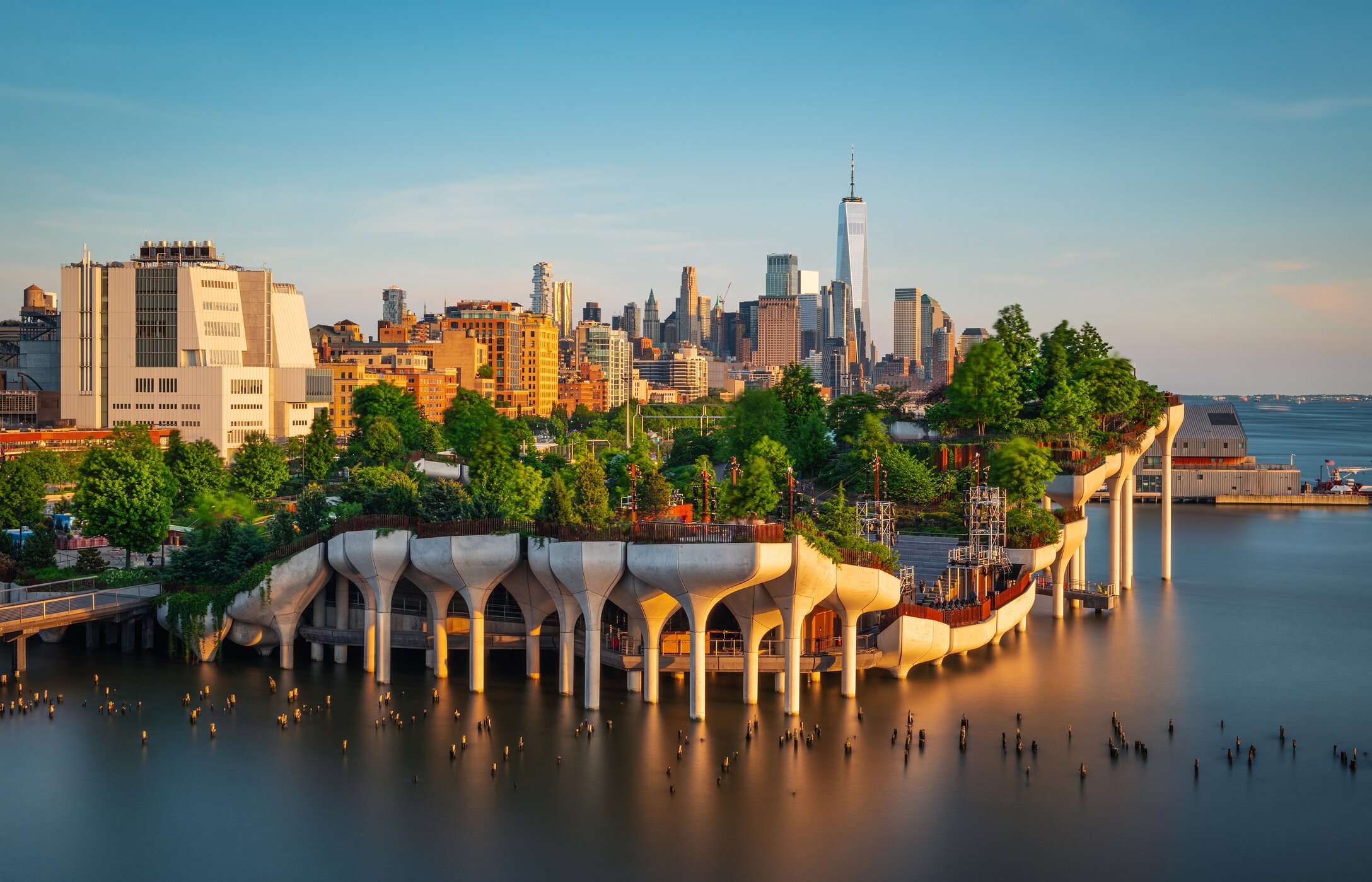 Small artificial island in New York City, with lush gardens, elevated walkways, and columns emerging from the water
