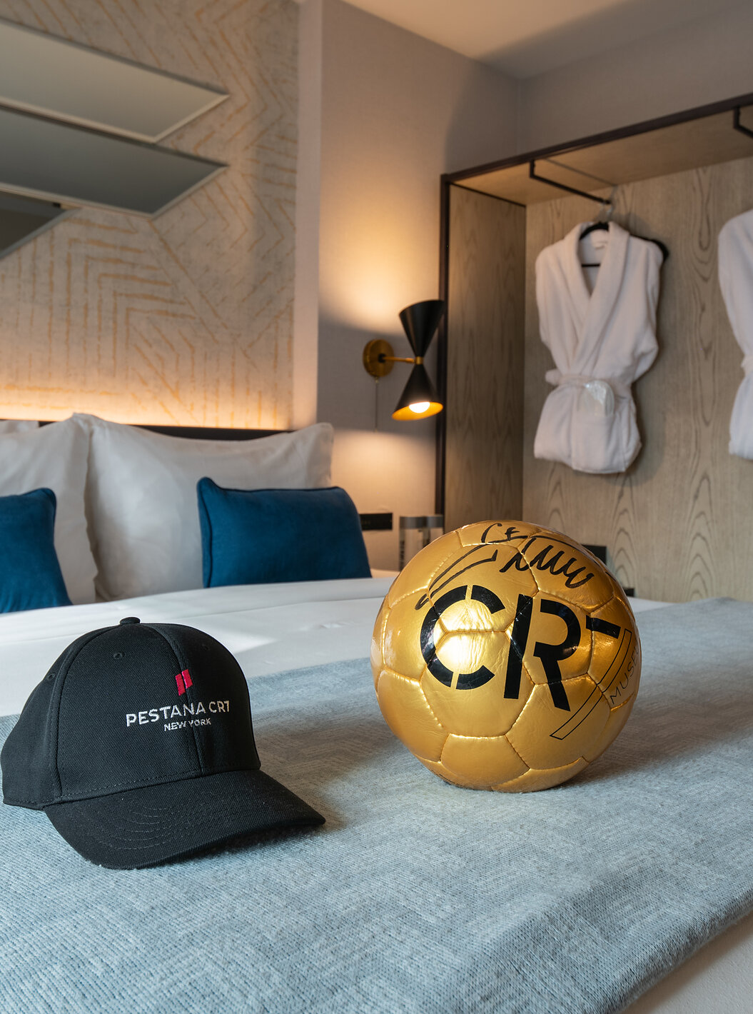 The Deluxe King Room ADA at Pestana CR7 Times Square has a double bed with a CR7 ball and hat