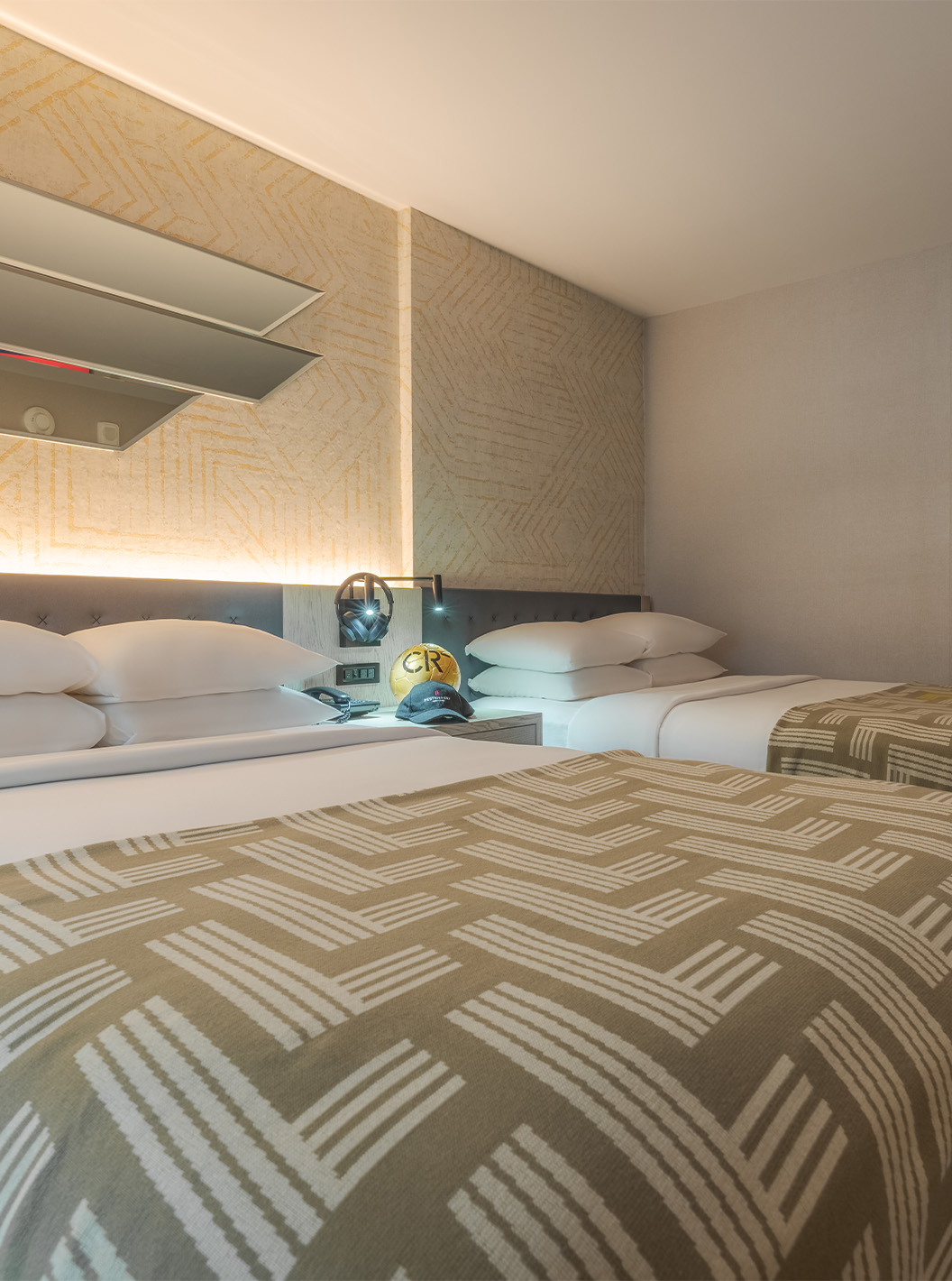 The Comfort Double ADA at Pestana CR7 Times Square has two beds with a bedspread with the number seven and a wardrobe