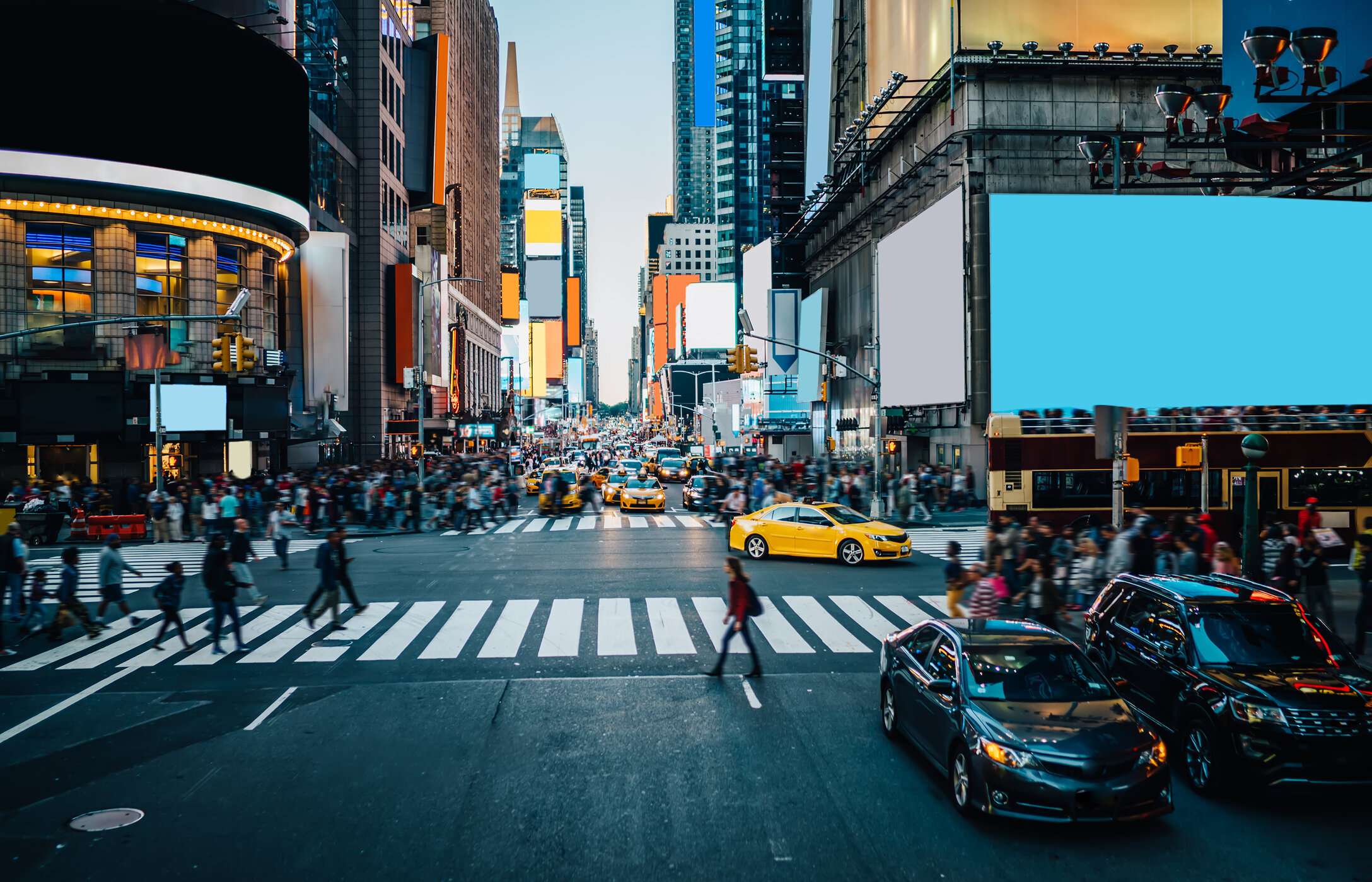 The famous Times Square in New York City, bustling with cars and people, its giant screens surrounded by tall buildings