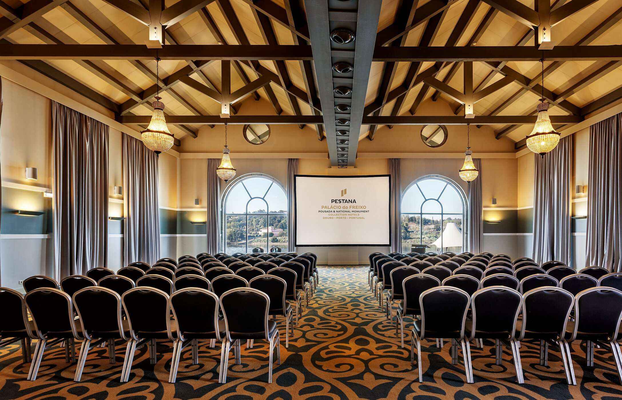 Spacious auditorium with multiple chairs for meetings or conferences, featuring modern decor and plenty of natural light