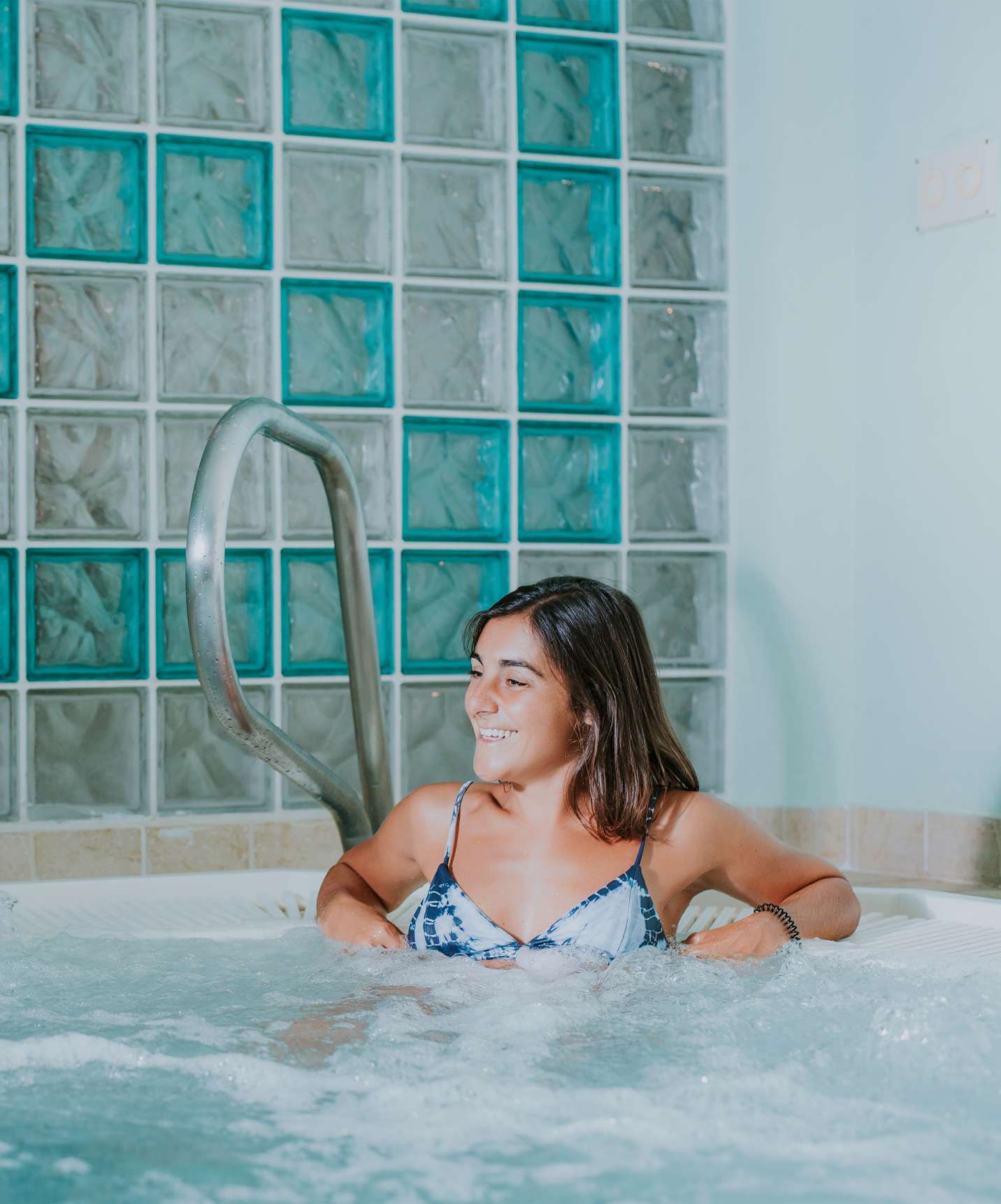 Two people socializing inside the jacuzzi at Pestana Quinta Perestrello, a hotel in Madeira near the beach, with a pool