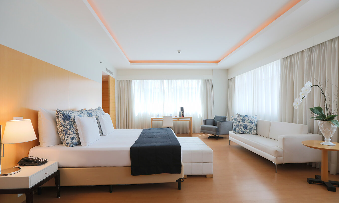 La Suite Ejecutiva del Pestana Curitiba es bastante espaciosa y luminosa, con cama de matrimonio king size, sofá y mesa