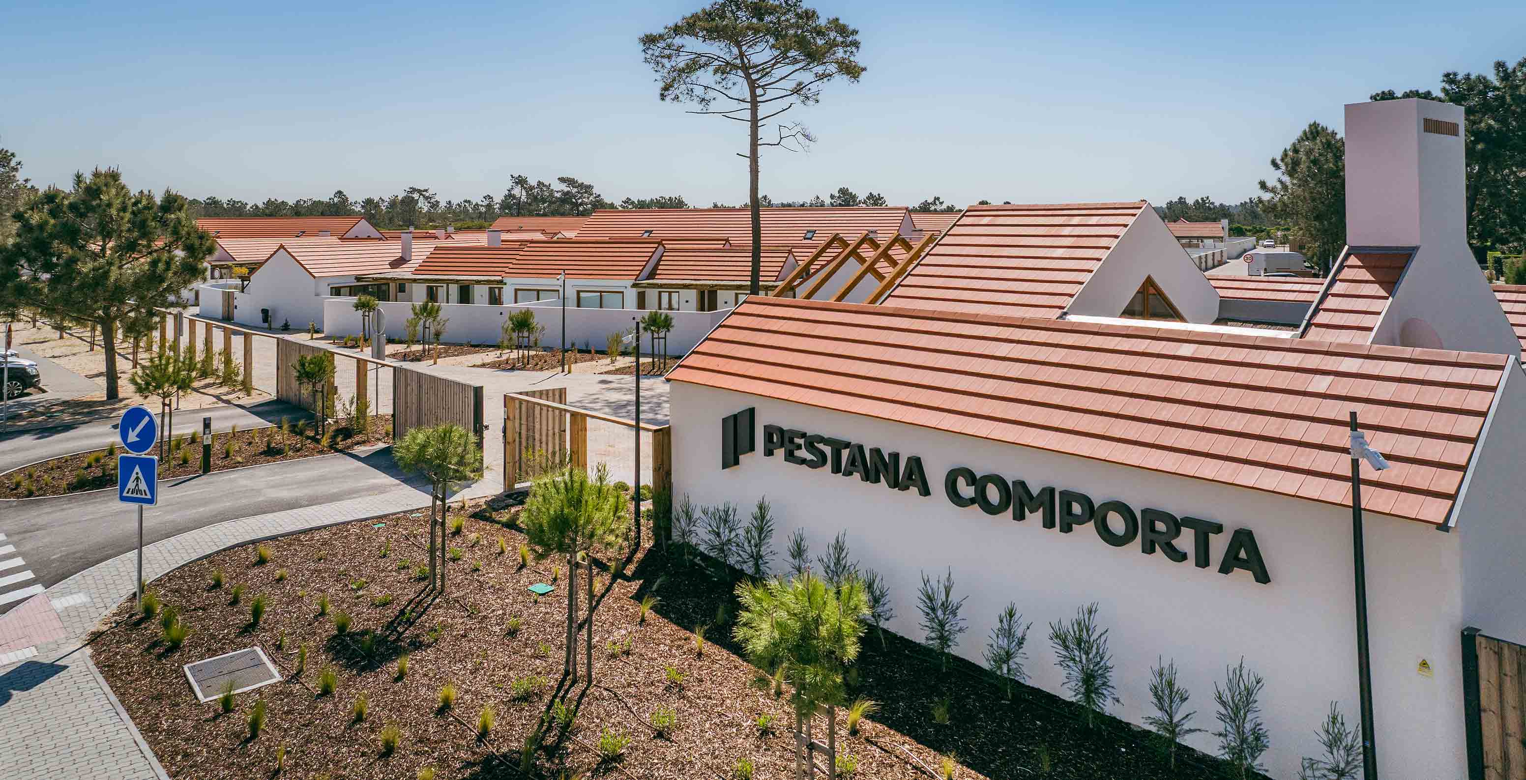 Vista del Pestana Comporta Village Residences, compuesto por villas con techos rojos, rodeadas de vegetación y árboles