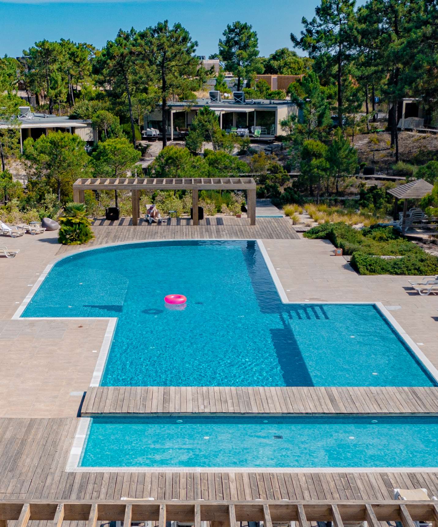 Piscina exterior del resort en Tróia, cerca de Comporta, con tumbonas alrededor y naturaleza a su alrededor