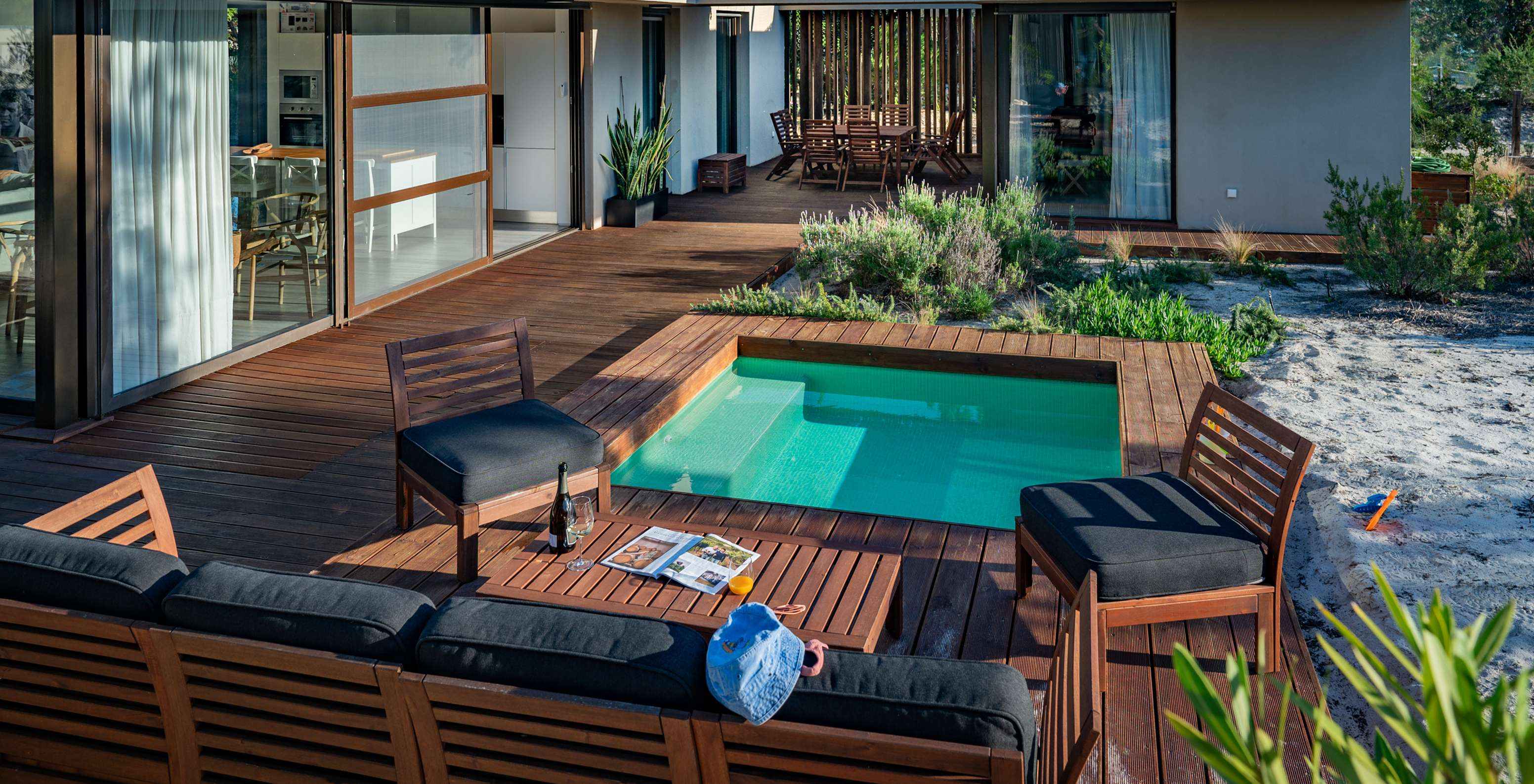 Las Beach Villas con Piscina Infantil del Pestana Tróia Eco Resort tienen sofás y sillas junto a la piscina infantil