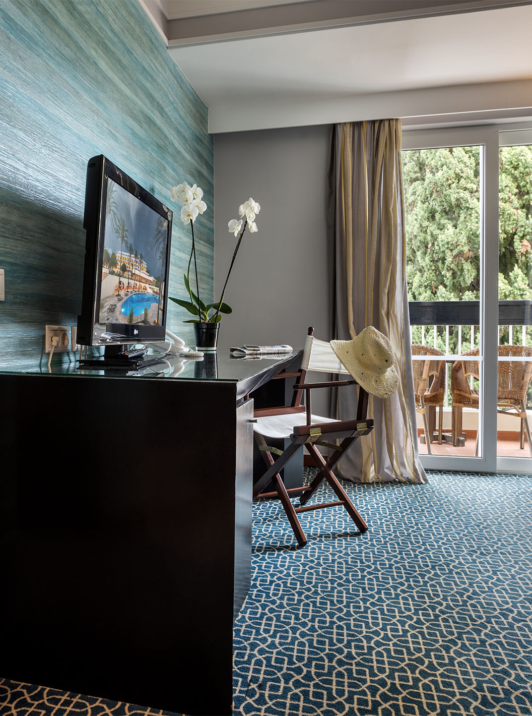 La Suite Vista Jardín del Pestana Alvor Praia tiene división entre sala con sofá, televisión y habitación con cama