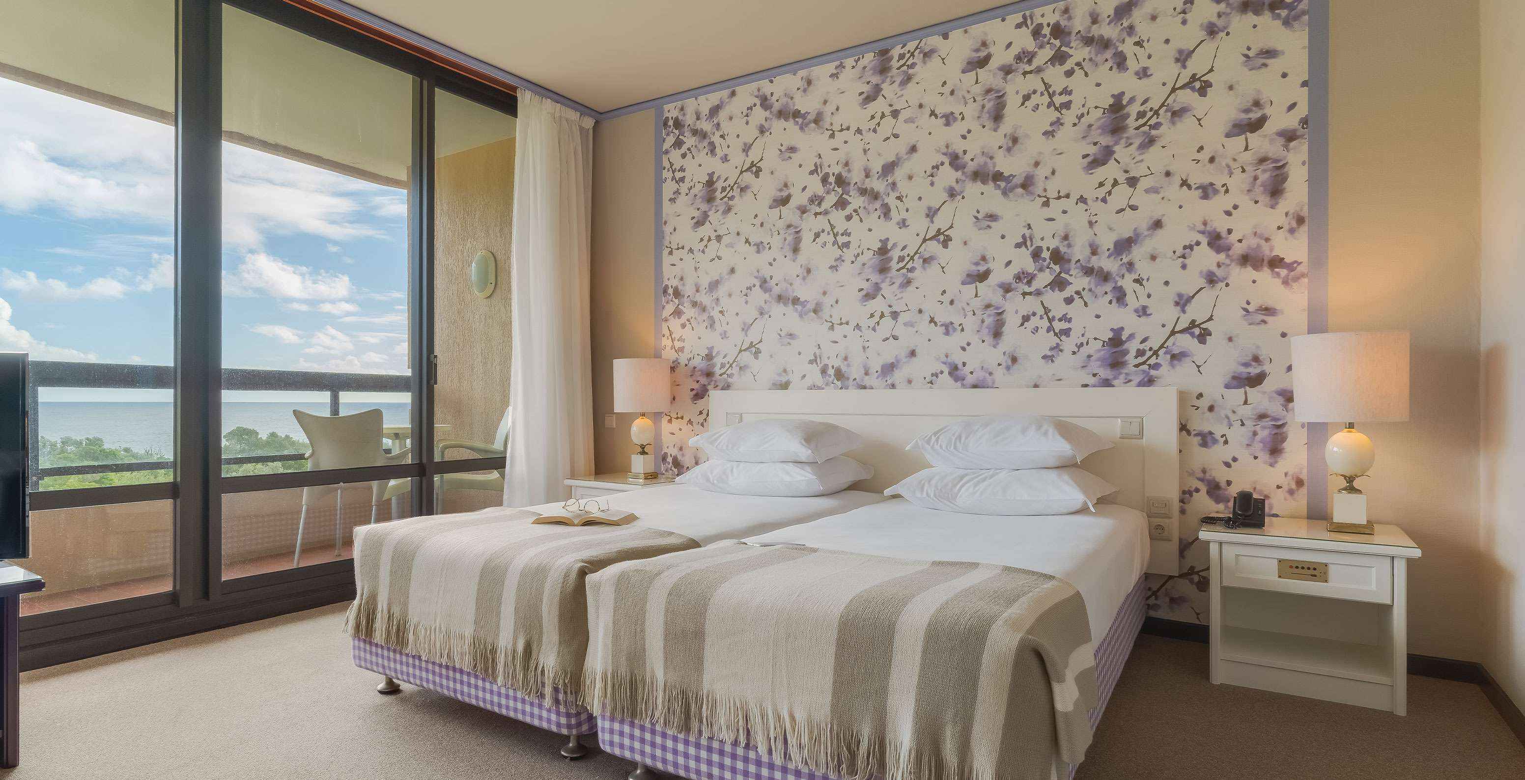 La Junior Suite Vista Jardín del Pestana Bahia Praia tiene un amplio espacio con dos camas individuales y un sofá