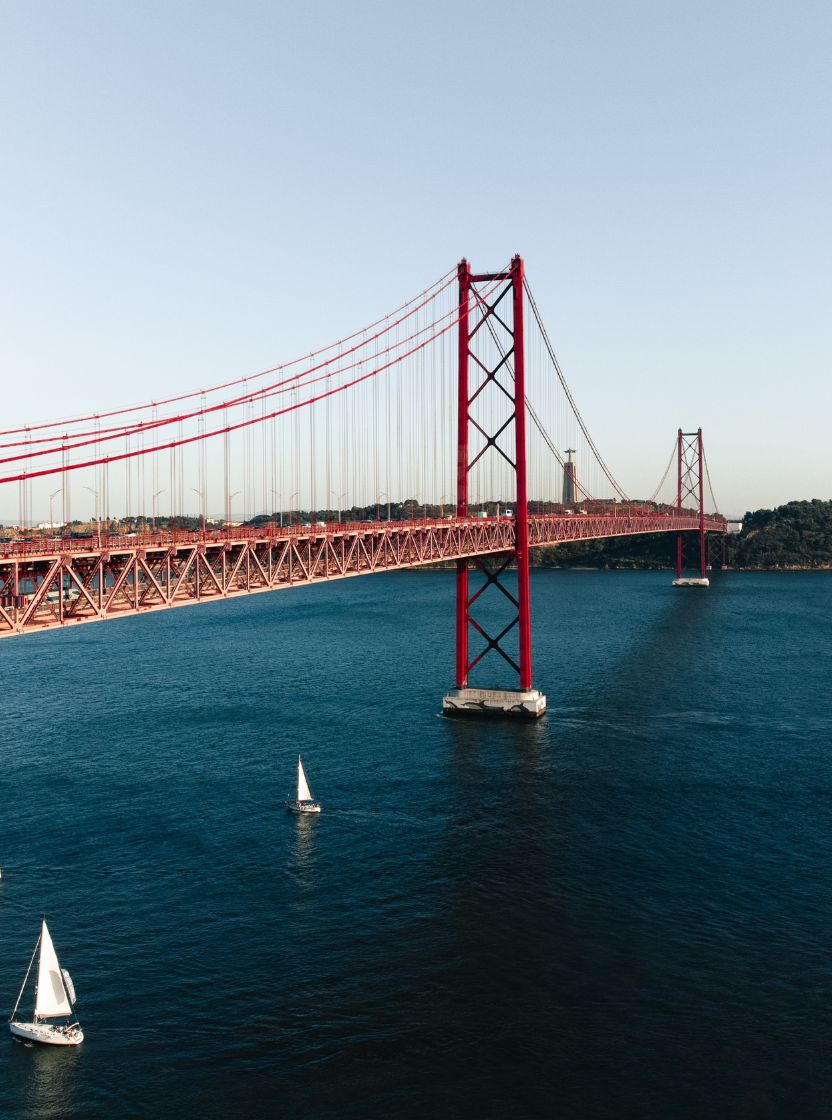 Vista panorámica de la ciudad de Lisboa, con el río Tejo y varios barcos, y el puente 25 de Abril