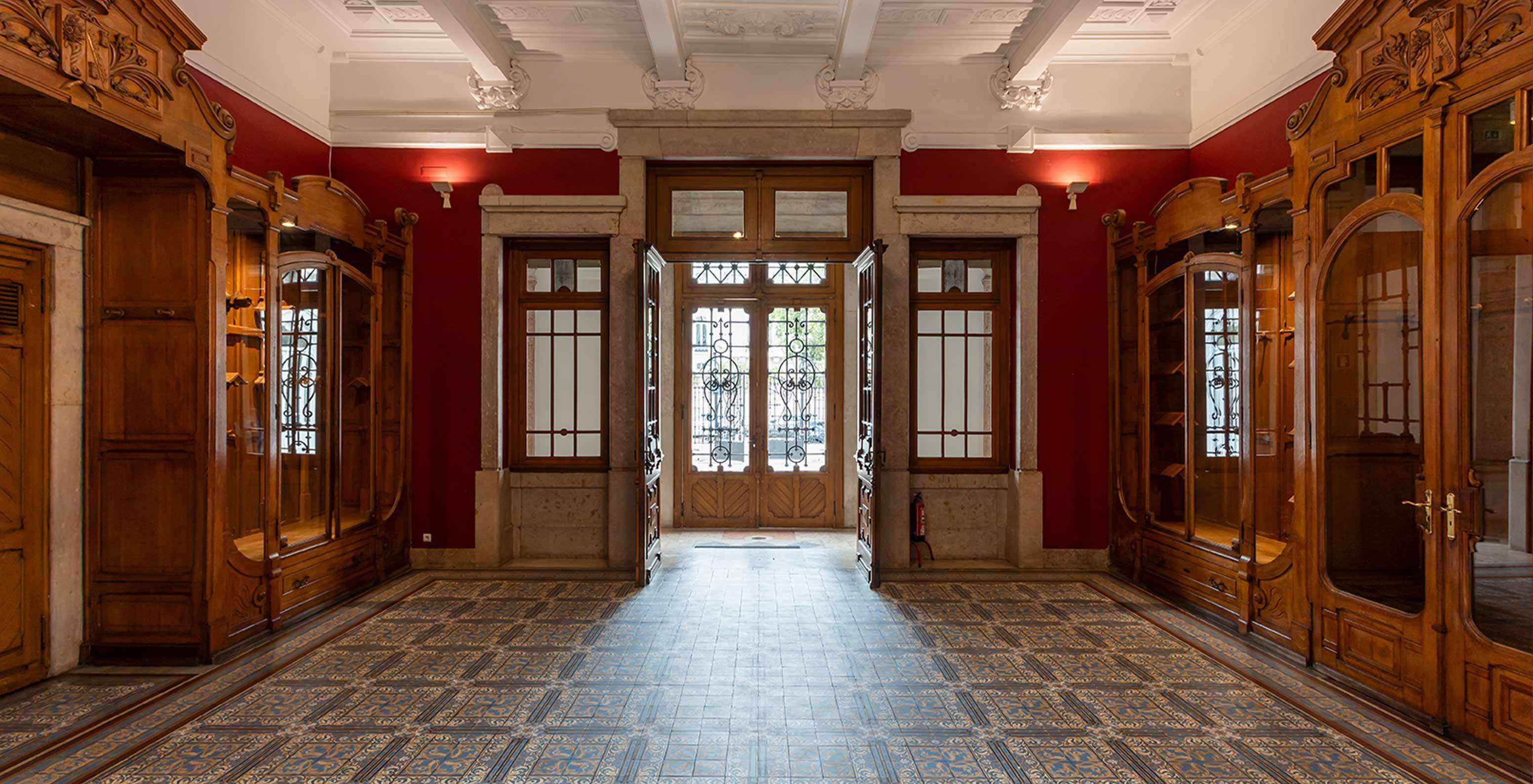 El Pestana Palace Lisboa tiene una sala de eventos con paredes rojas y muebles antiguos de madera