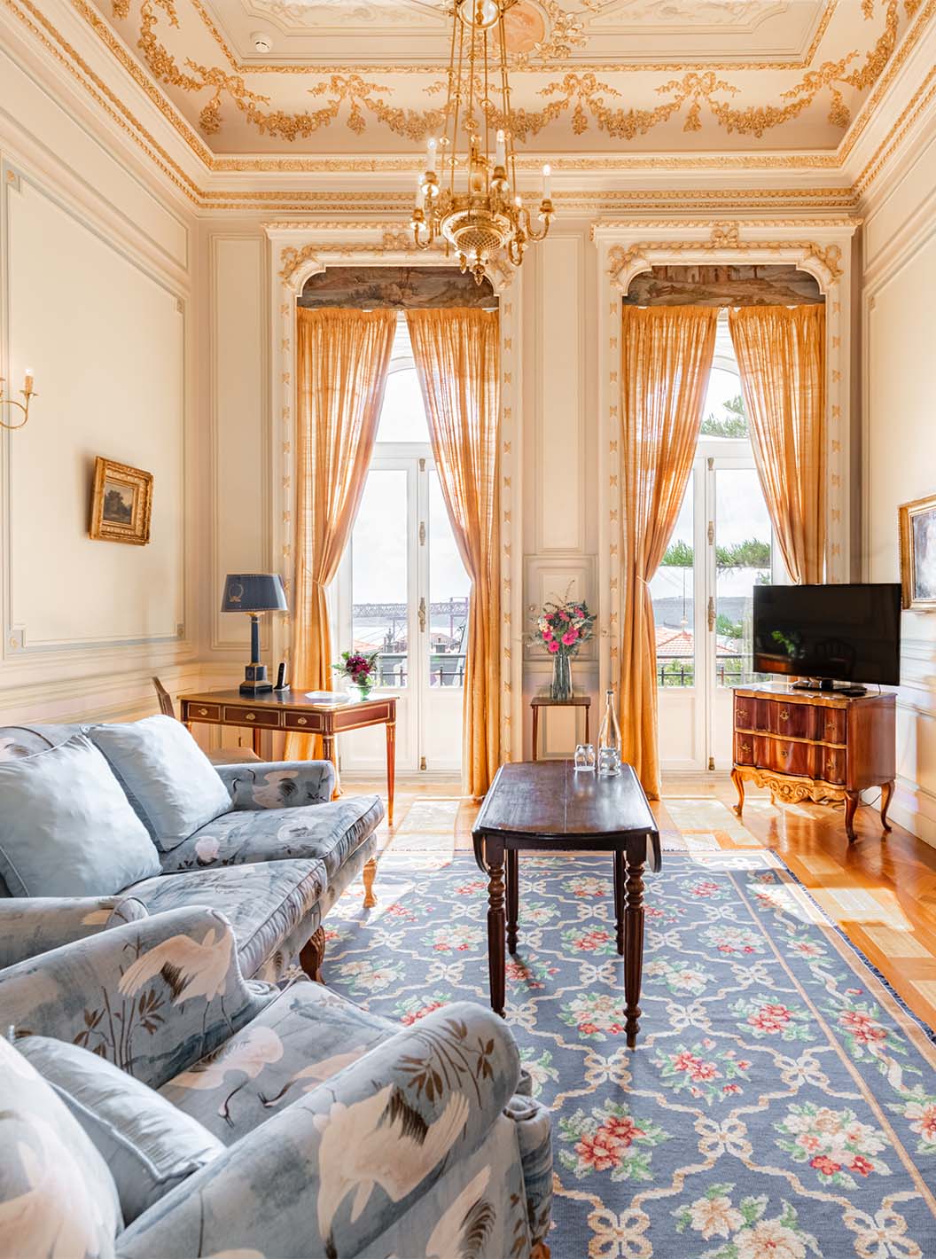 La Suite D. Manuel/ D. Luís Filipe del Pestana Palace Lisboa tiene una sala de estar lujosa con sofá, televisión y ventana