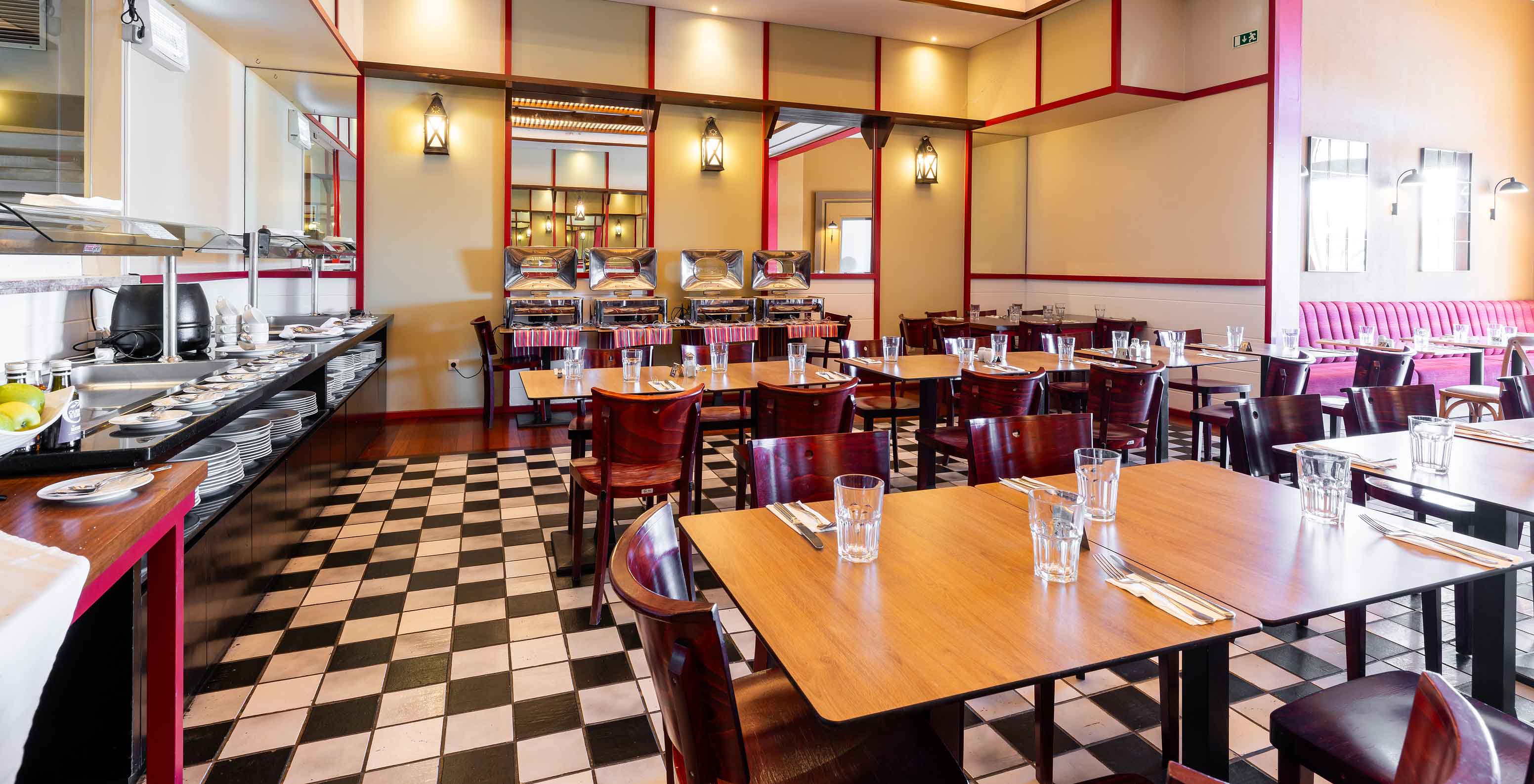 El restaurante Luigi, del Resort de 5 estrellas en Porto Santo, tiene un suelo de azulejos blancos y negros y sillas oscuras.