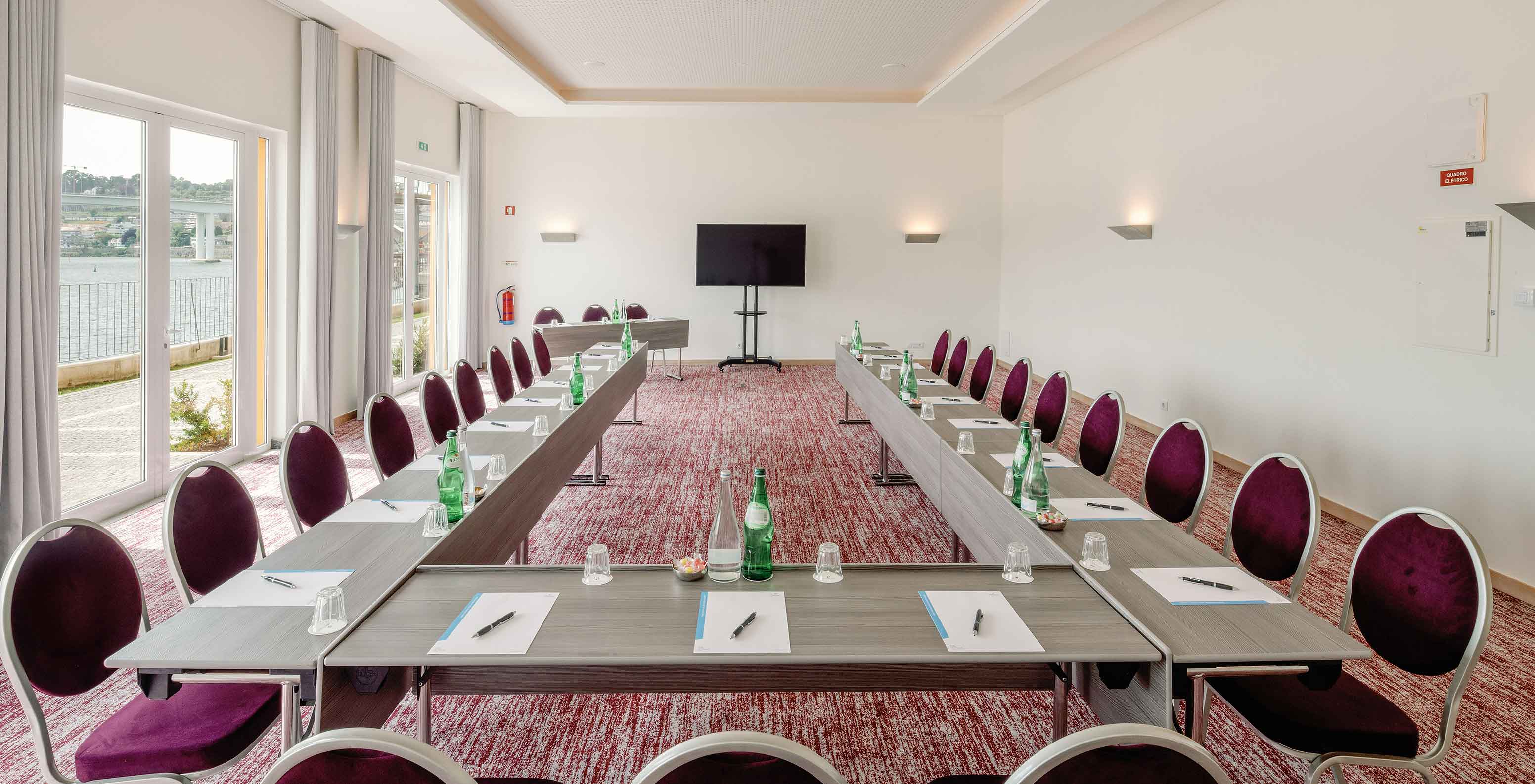 Sala Douro IV con mesas en forma de U en el Pestana Douro Riverside Hotel con piscina frente al río Duero