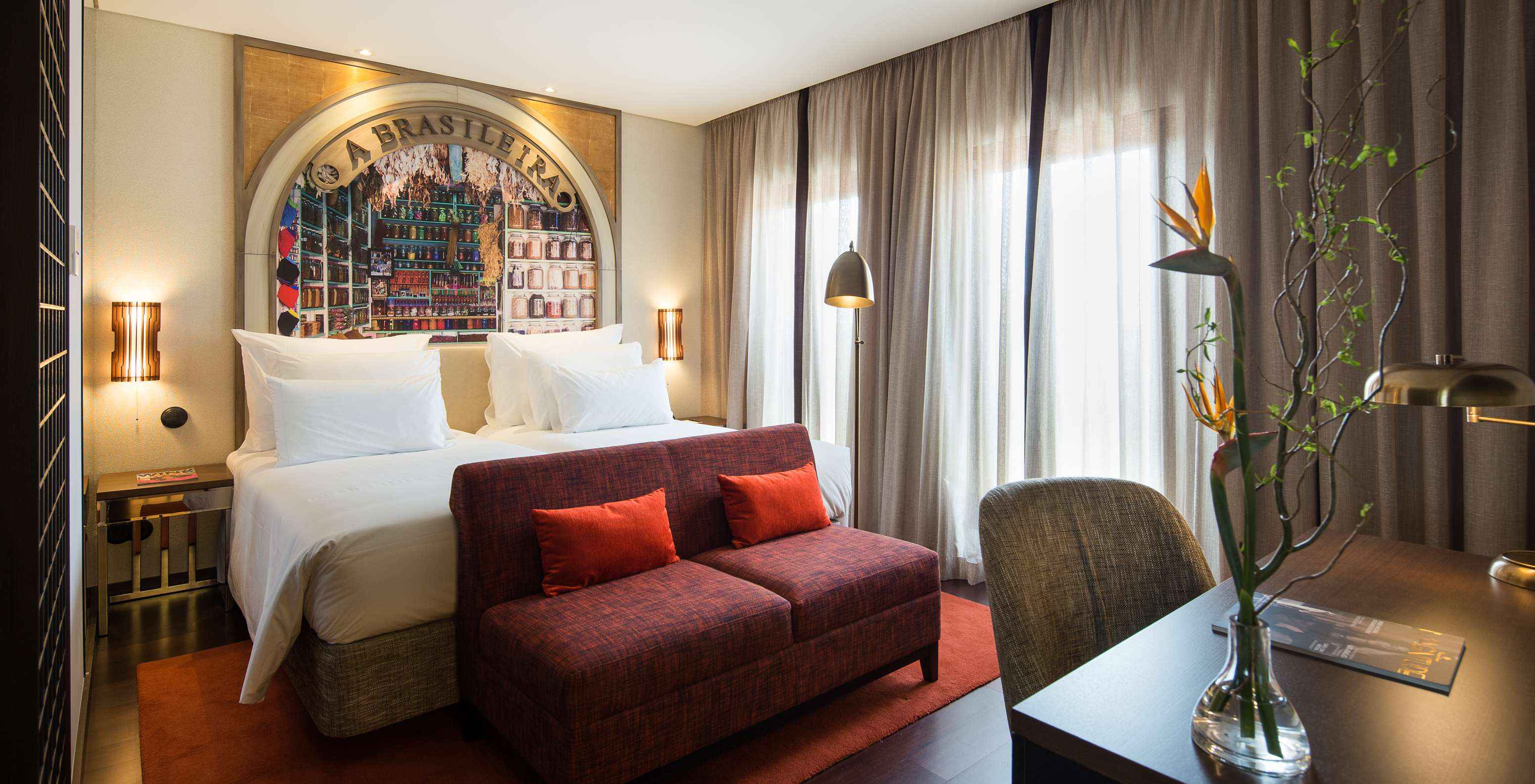 El Deluxe Superior Grand View del Pestana Porto - A Brasileira tiene una cama de casal con un sofá al fondo y un escritorio