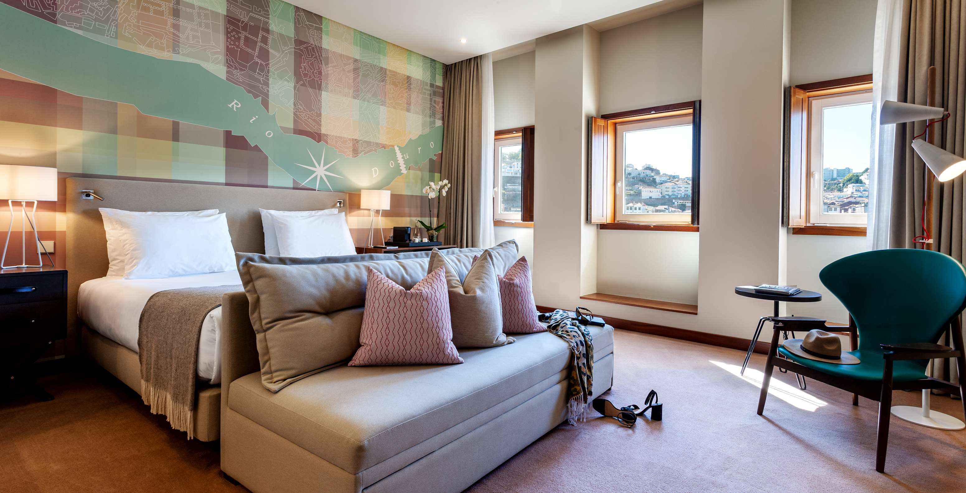 El Vintage Front View del Pestana Vintage Porto tiene una cama de matrimonio con un sofá al pie, tres ventanas y un sillón