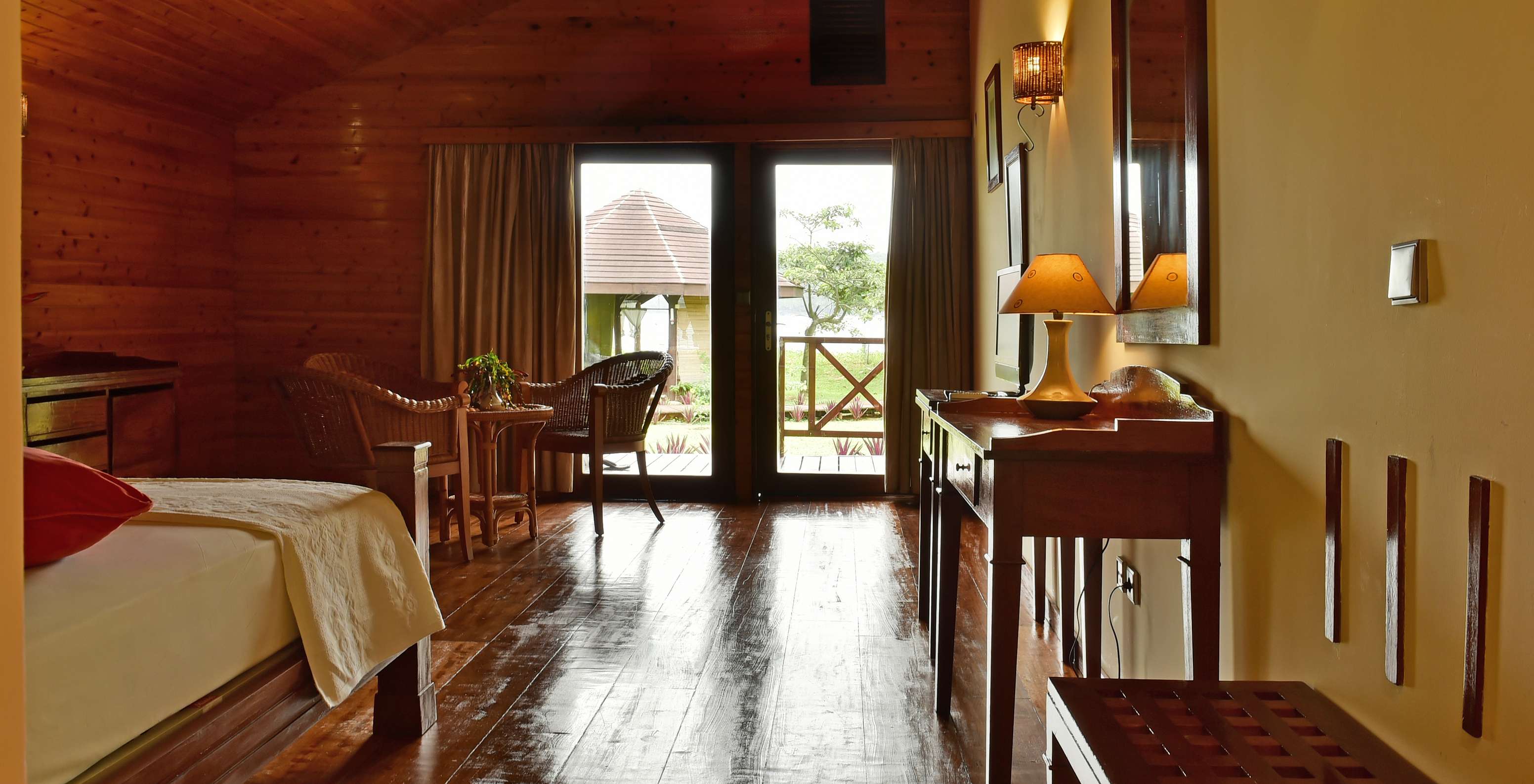 El Duplo Superior del Pestana Equador Ilheu das Rolas tiene una cómoda de madera, un espejo y ventana con vista al jardín