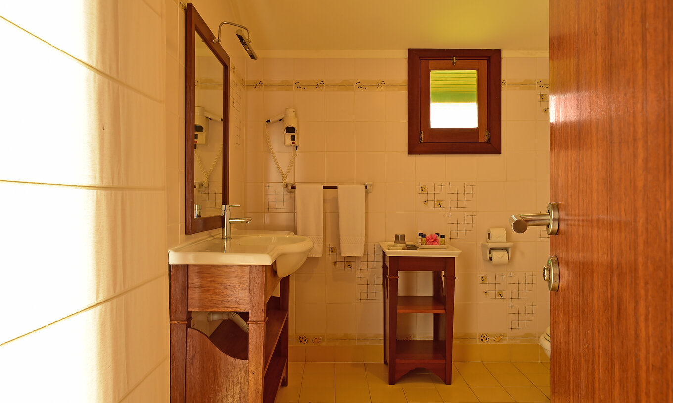 El Duplo Superior del Pestana Equador Ilheu das Rolas tiene un baño con lavabo, espejo, secador de pelo y ventana