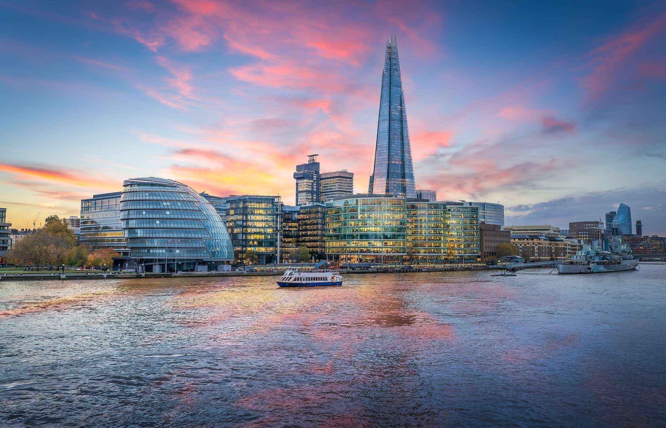 Vista panorámica de The Shard al atardecer, con un barco navegando en el río Támesis en Londres, Reino Unido.