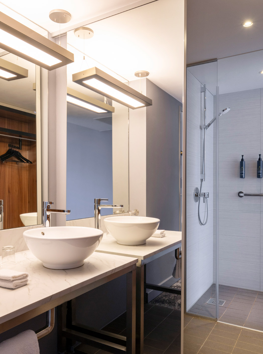 De Standard Twin van Pestana Brussels Schuman heeft een badkamer met een wastafel, een grote spiegel en een douche