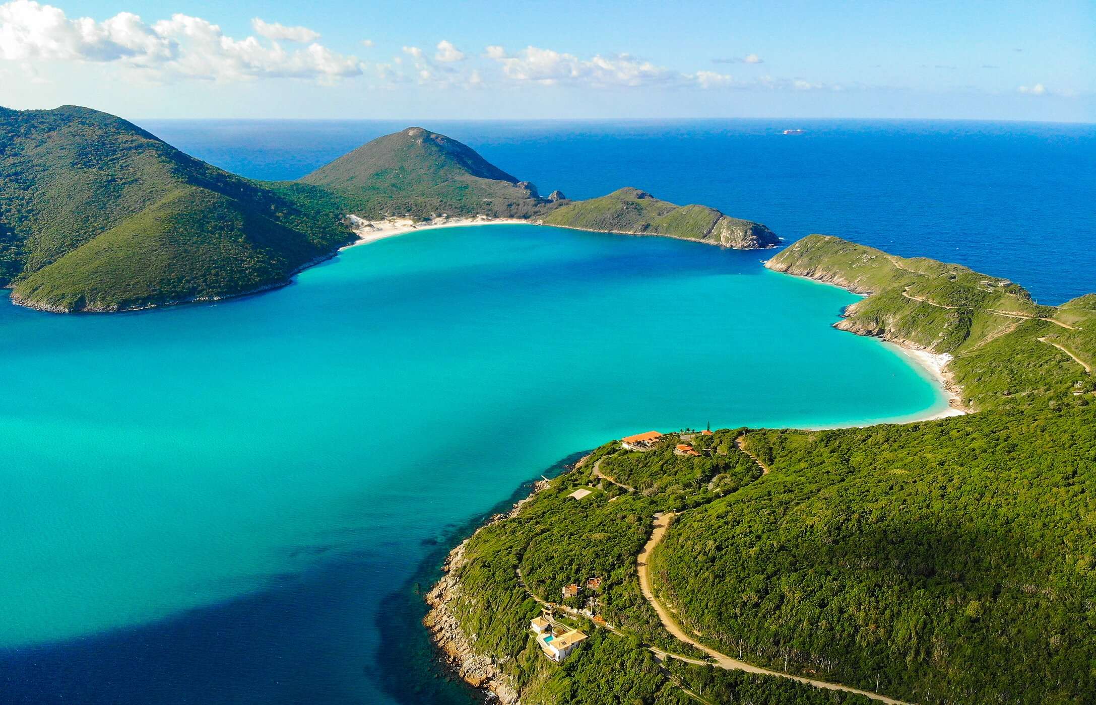 Luchtzicht op Cabo strand, met kristalhelder water en omgeven door beboste bergen, in Rio de Janeiro, Brazilië
