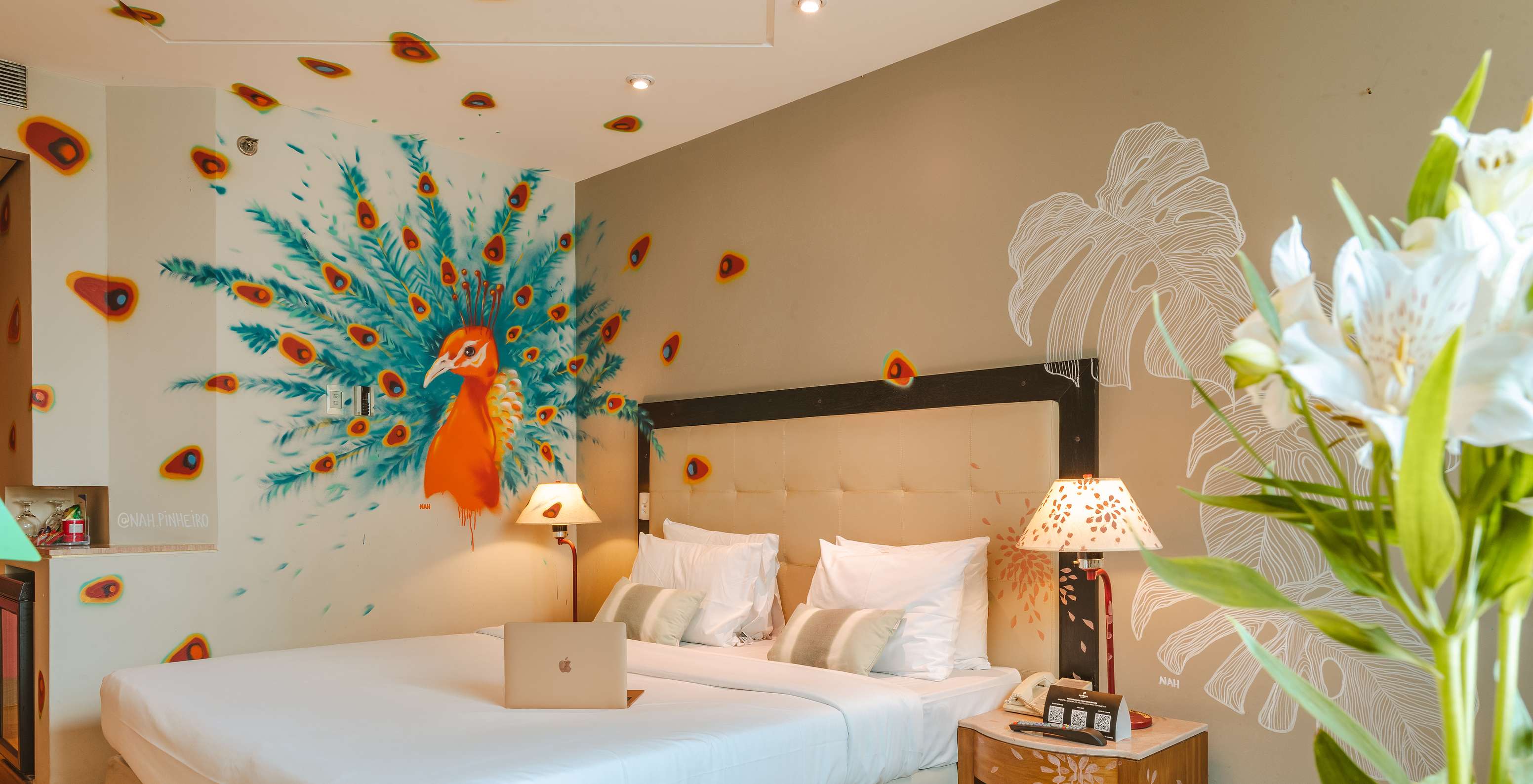 Kamer ingericht door kunstenaar Nah Pinheiro, met een gekleurde pauw op de muur, in een 4-sterrenhotel in São Paulo
