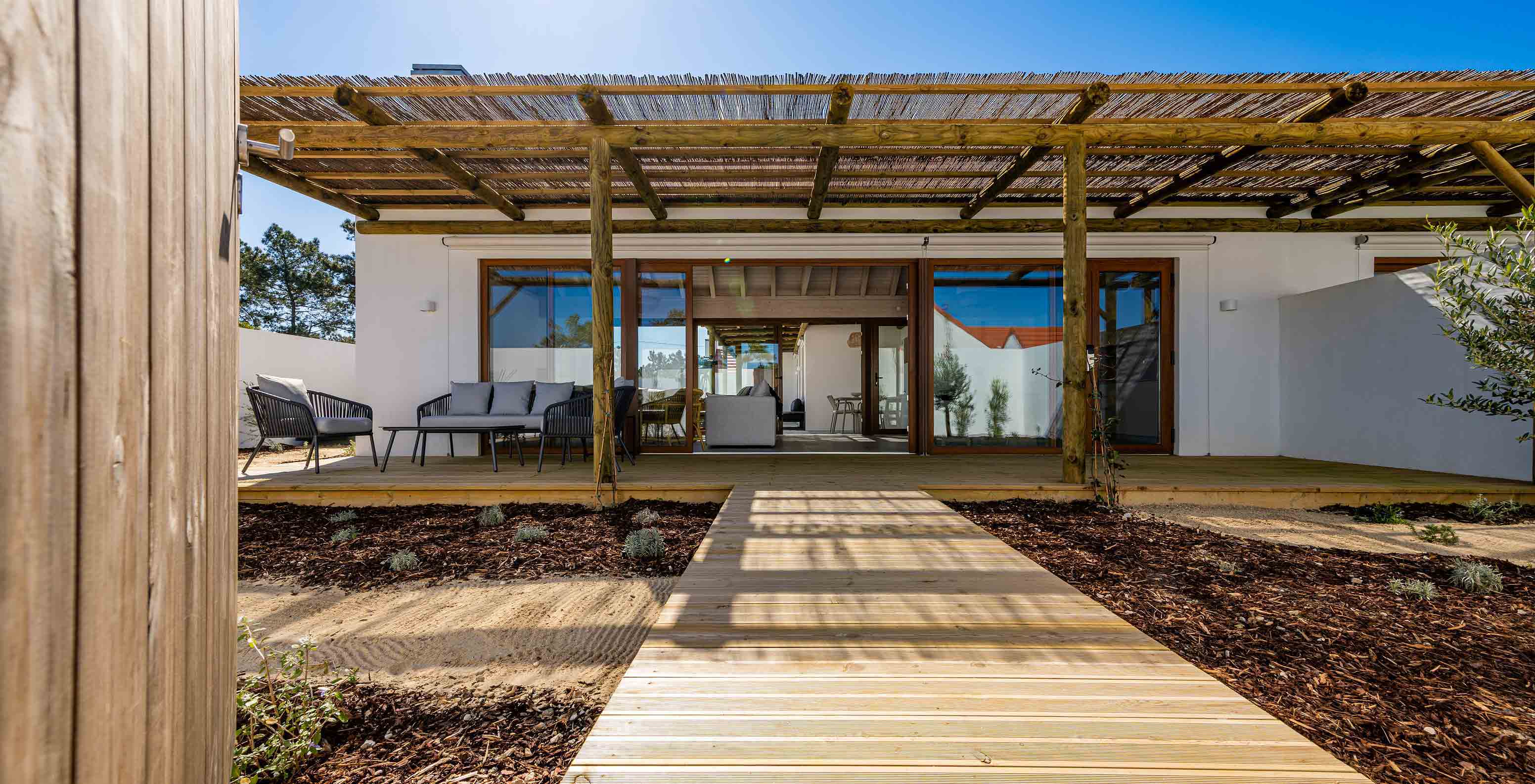 De Premium Villa bij Pestana Comporta Village Residences heeft een entree met een houten dek, een pergola en een tuin