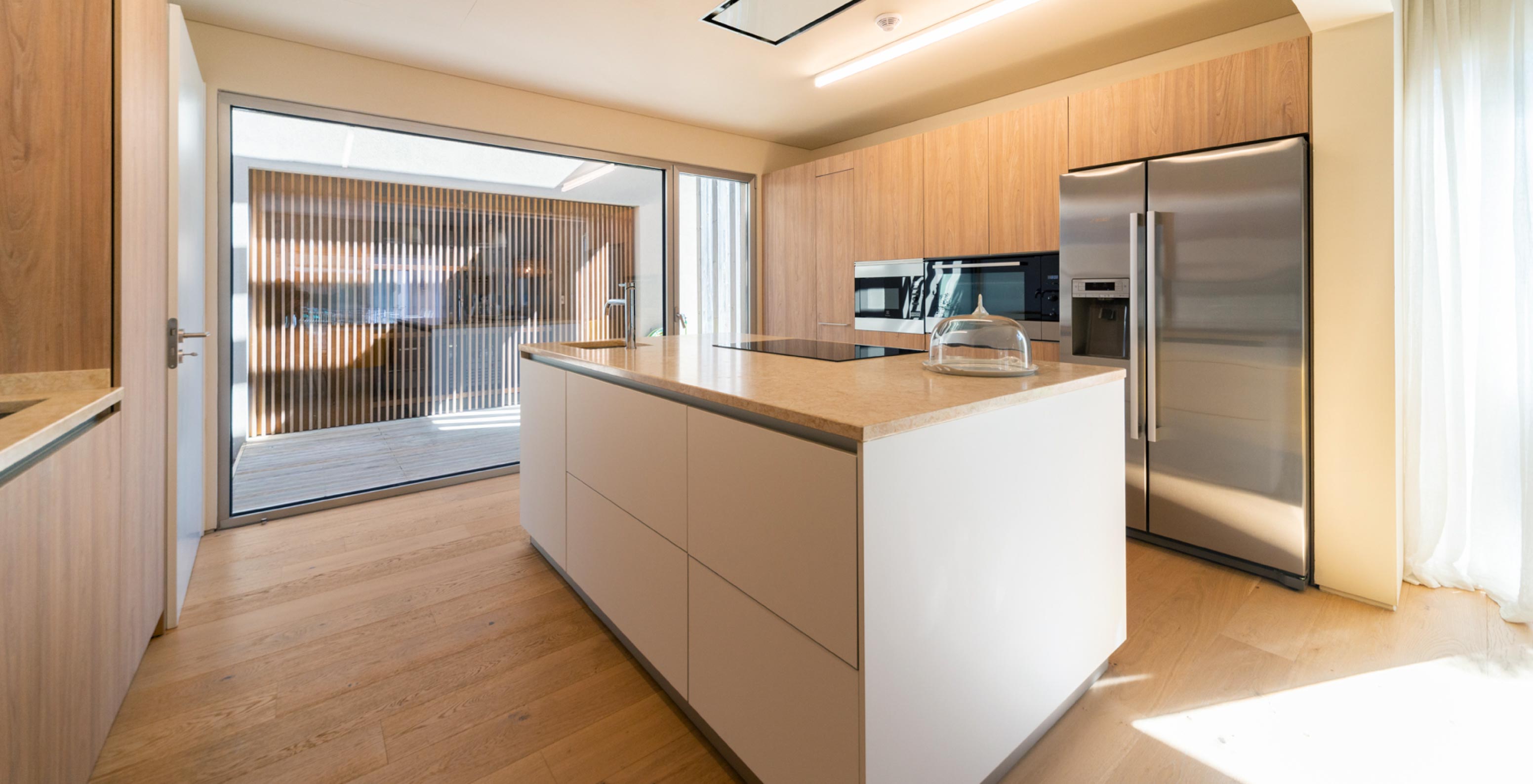 De exclusieve villa met zwembad van Pestana Tróia Eco Resort heeft een keuken met houten kasten en een centraal eiland