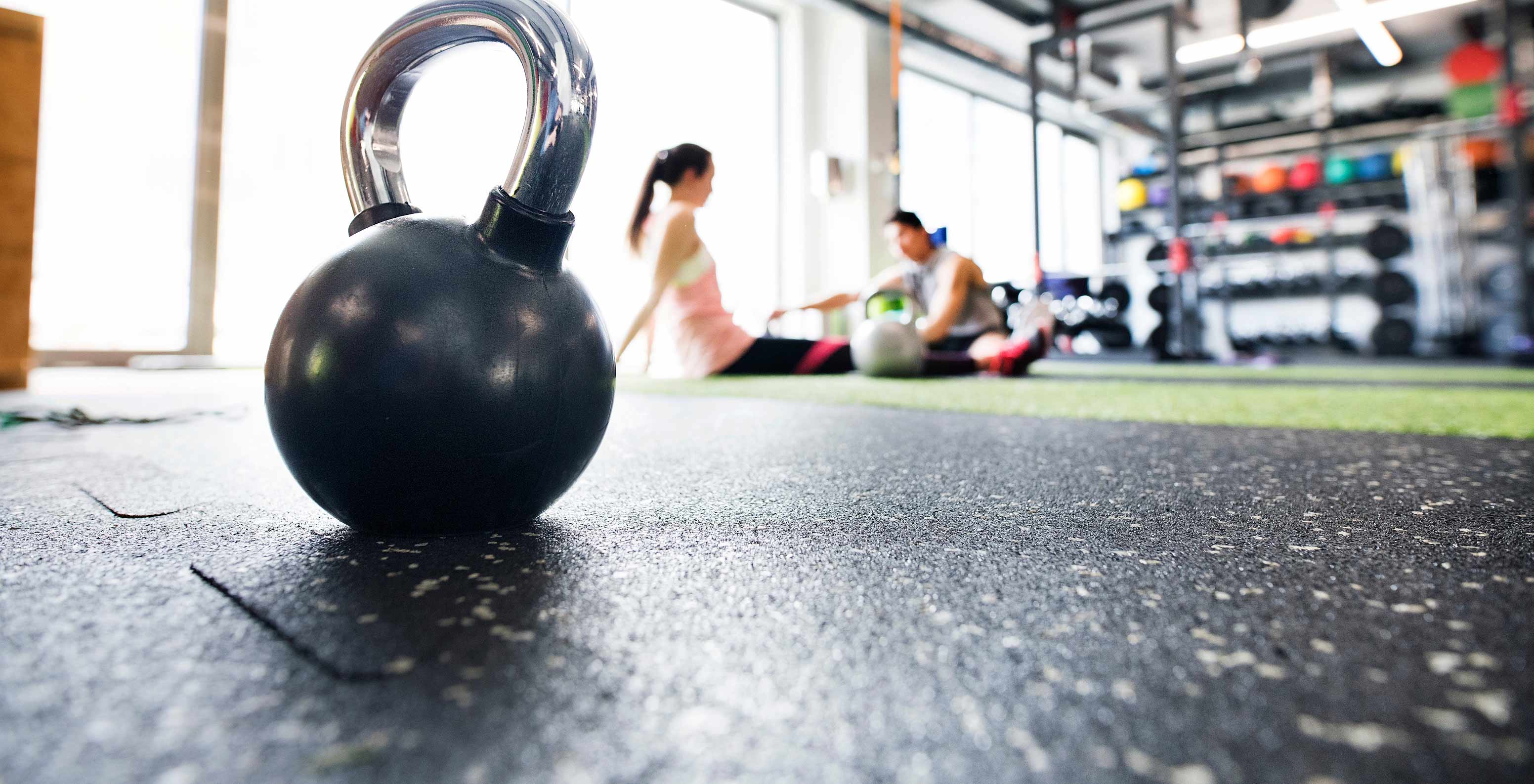 Focus op een kettlebell, gasten trainen in de gym van Pestana Alvor Park, 4-sterren Aparthotel in Alvor met zwembad