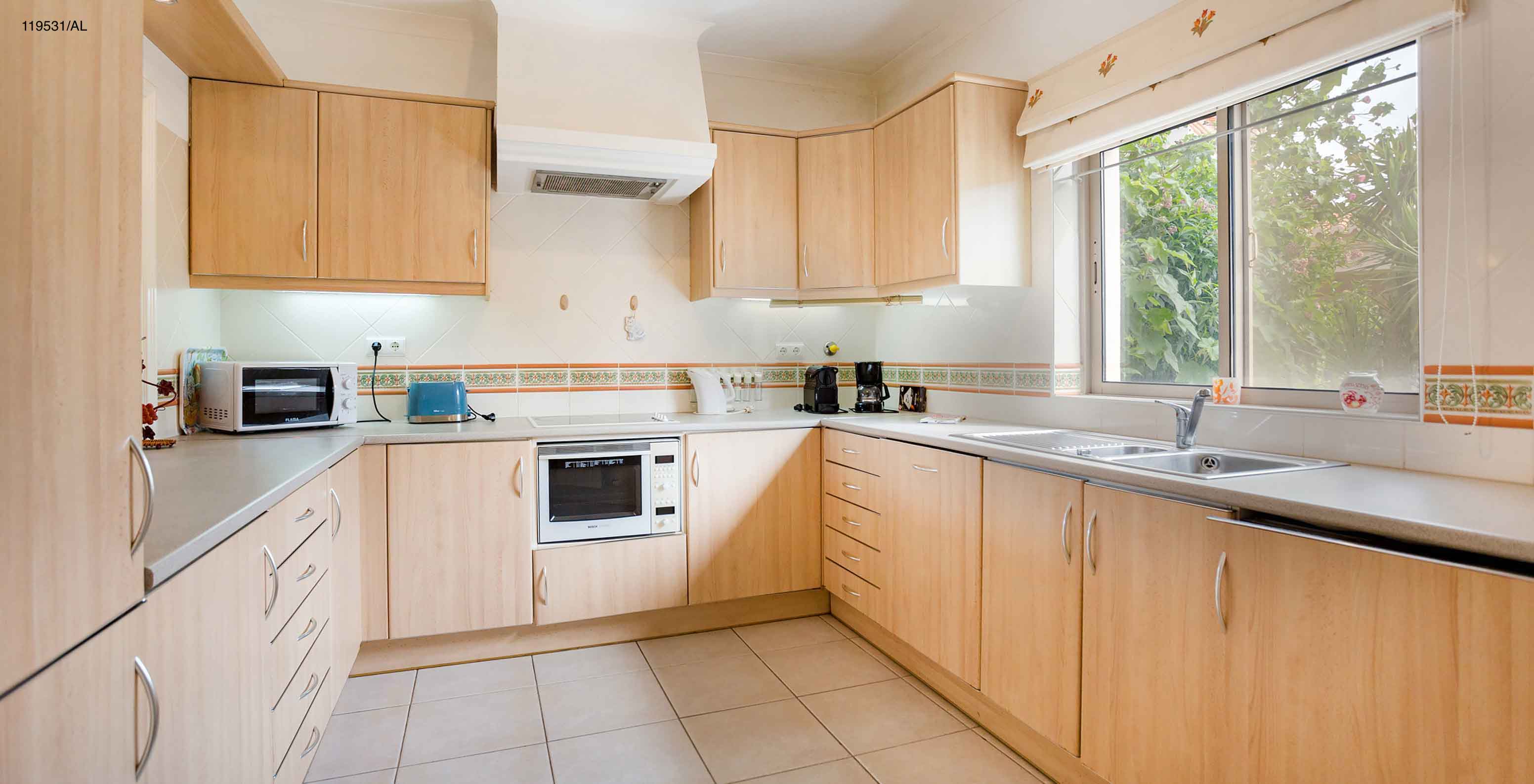 Het appartement Pestana Carvoeiro Golf T1 Standard heeft een keuken met houten kasten en apparatuur