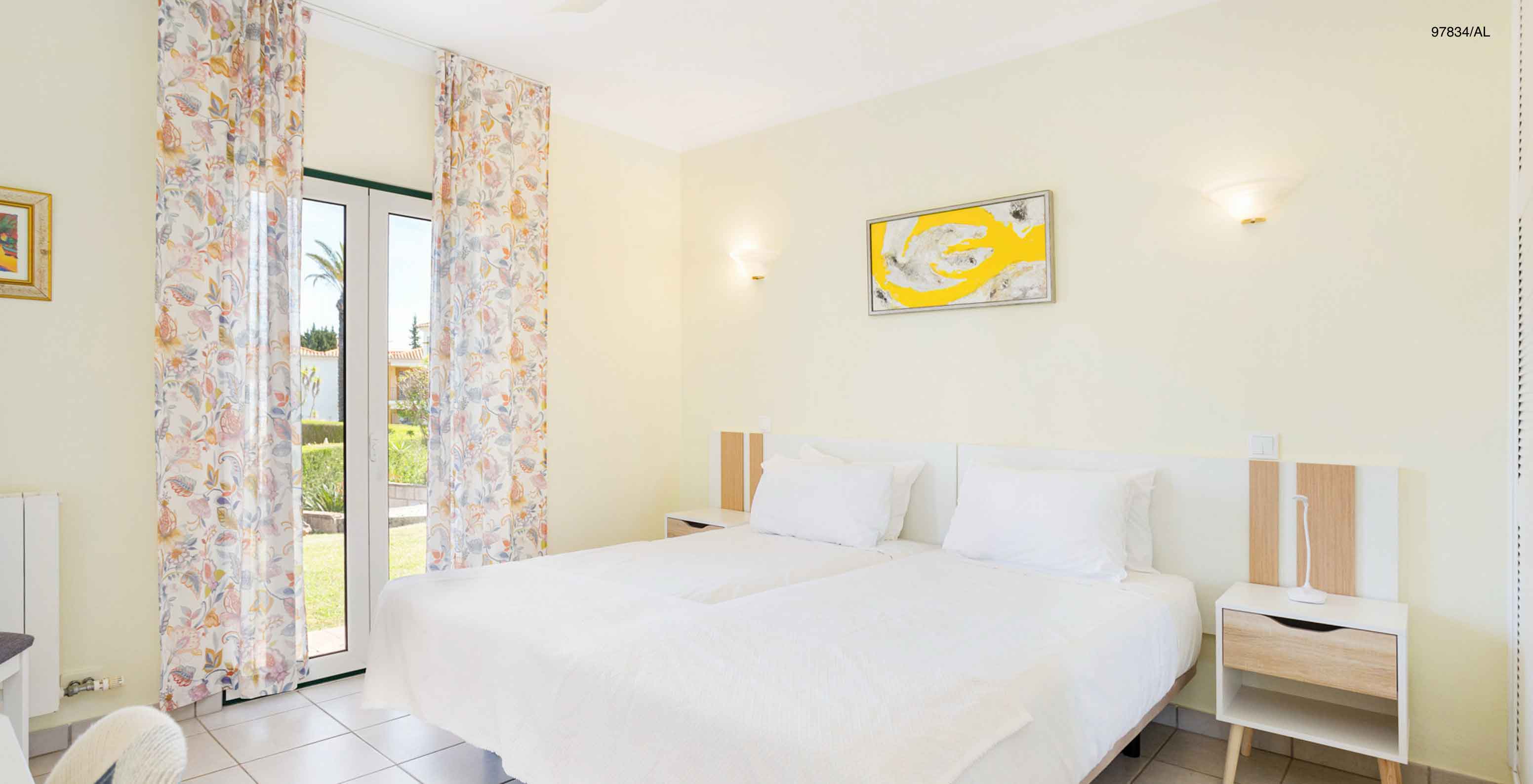 Het appartement Pestana Carvoeiro Golf T2 Superior heeft een slaapkamer met twee eenpersoonsbedden en een nachtkastje